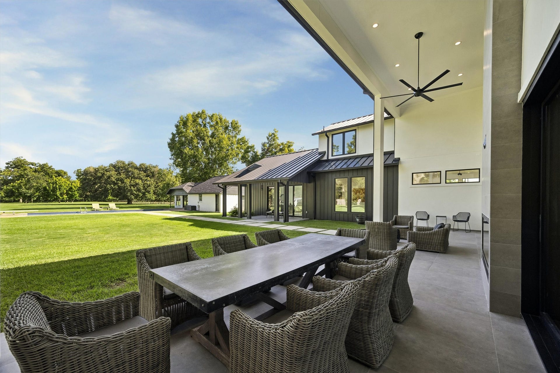 5210 Manor Drive, Sugar Land, TX 77479 An elegant covered dining terrace offers an extraordinary setting for memorable gatherings, with sweeping views of the manicured grounds and seamless access to the home's outdoor living spaces.