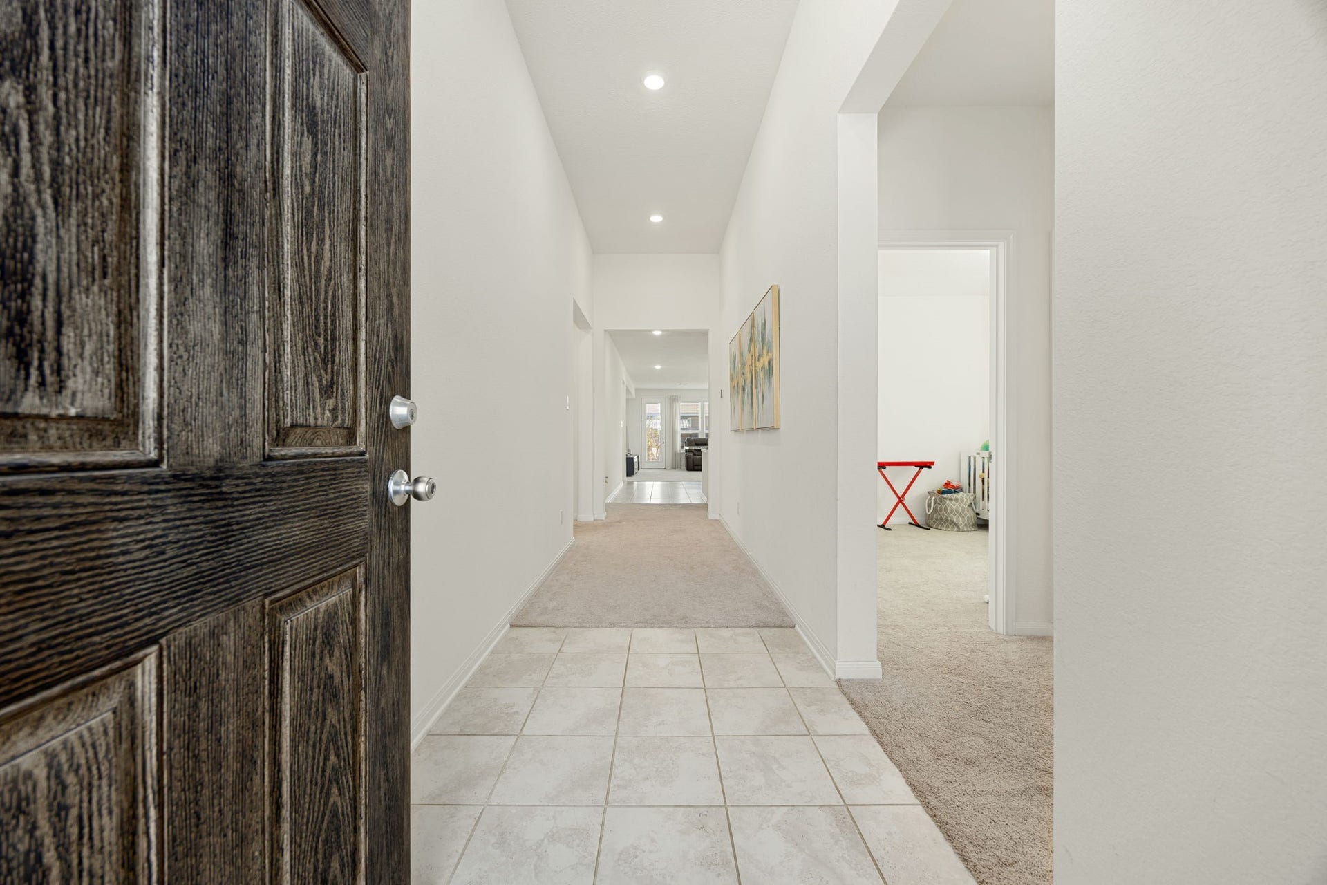 2023 Katalonia Lane, Fresno, TX 77459 Step inside a bright and airy foyer featuring neutral tile flooring, high ceilings with recessed lighting, and a long hallway that leads seamlessly into the main living spaces.
