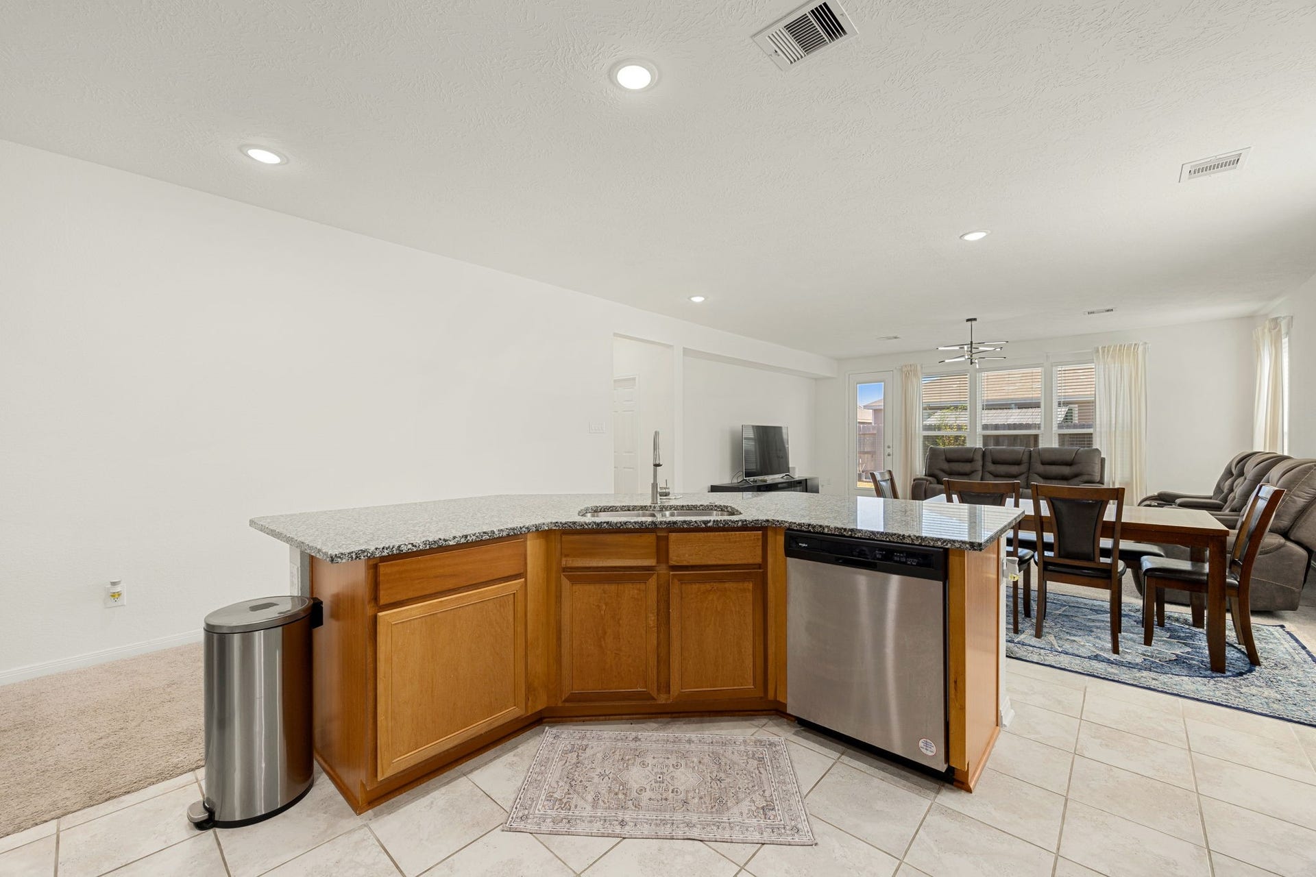 2023 Katalonia Lane, Fresno, TX 77459 Enjoy a truly commanding perspective from the heart of the kitchen. This wide-angle view from the expansive island demonstrates how effortlessly the home chef can stay connected with guests or family, offering sweeping sightlines across the dining area, family room, and out to the sunlit backyard.