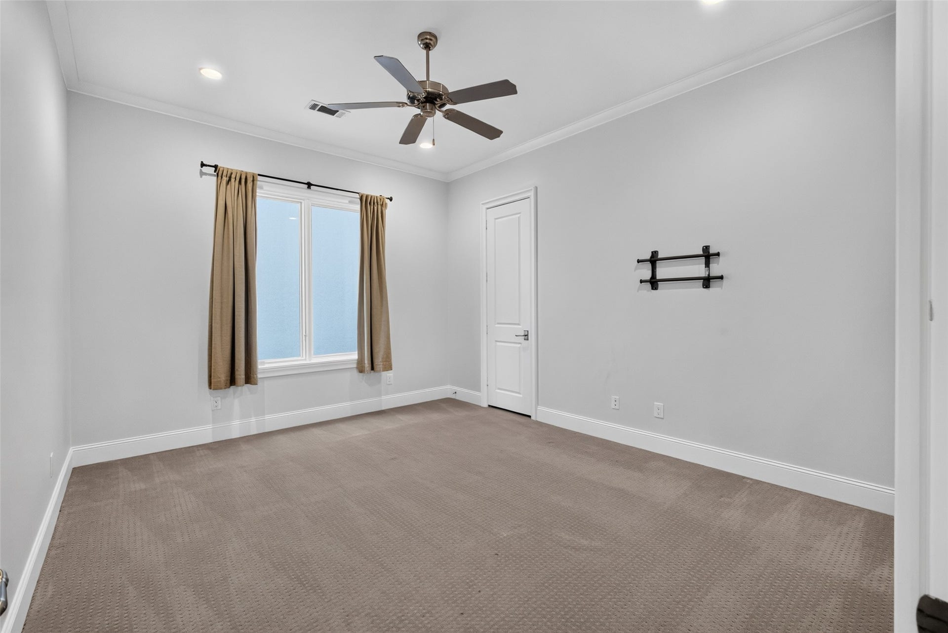 Second bedroom with TV mount, ceiling fan and bright lighting