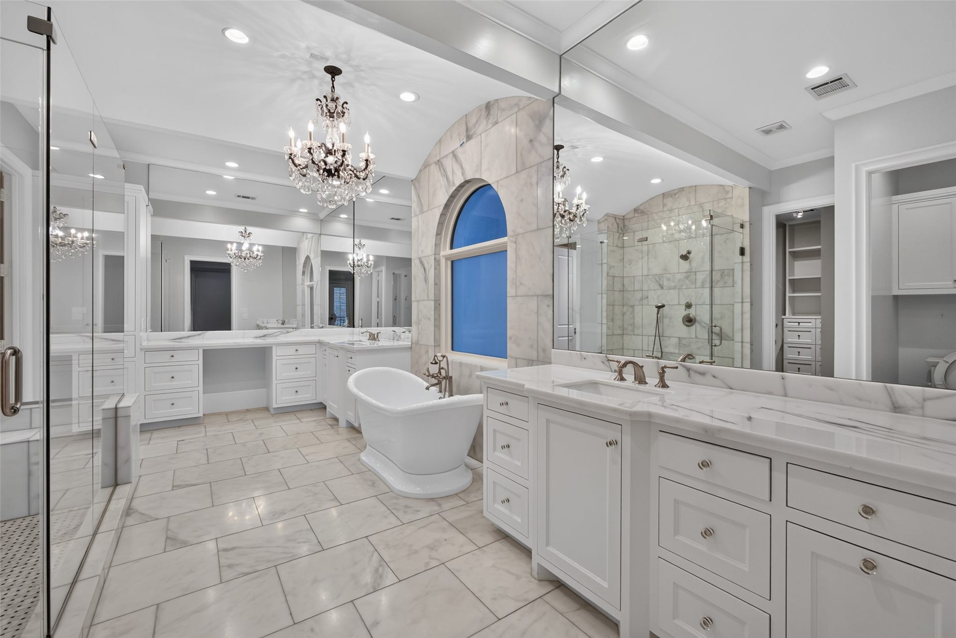 Welcome to your luxury spa-like bathroom! With generous vanities, counter to ceiling mirrors, chandelier and marble you will love this serene retreat.