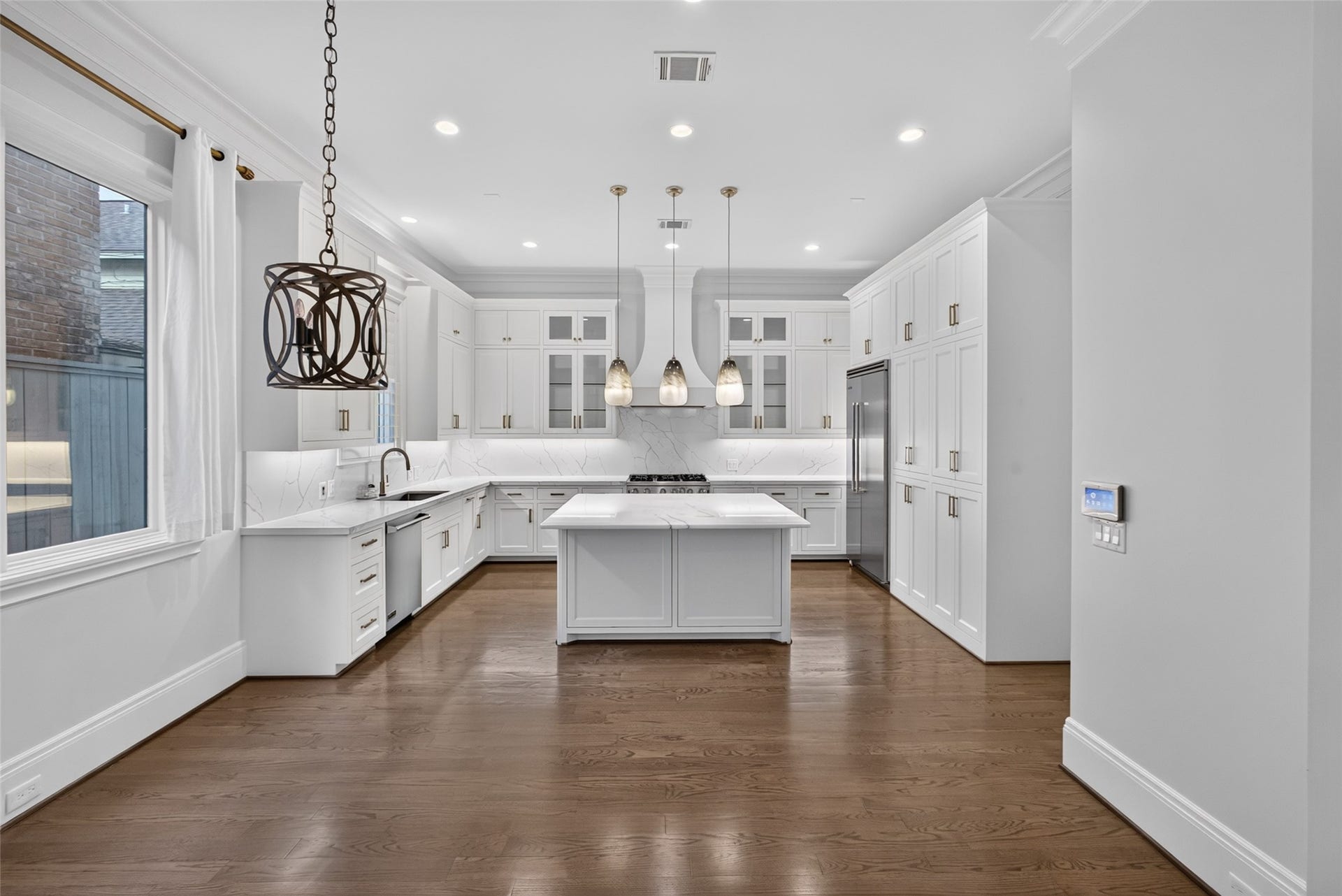 Large picture window by the breakfast area and another window above the sink. Beautiful cabinets, tons of pantry storage and a great island.