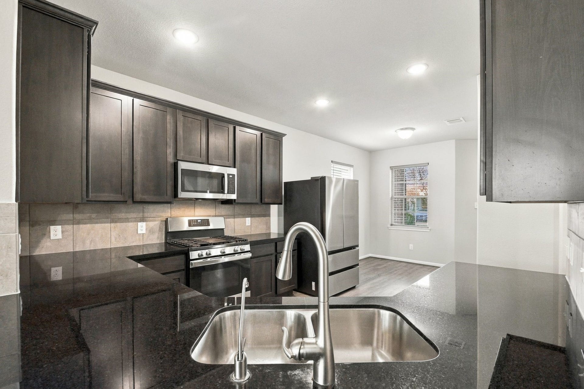 10423 Rochester Hills Lane, Tomball, TX 77375 The kitchen features granite countertops and a high bar