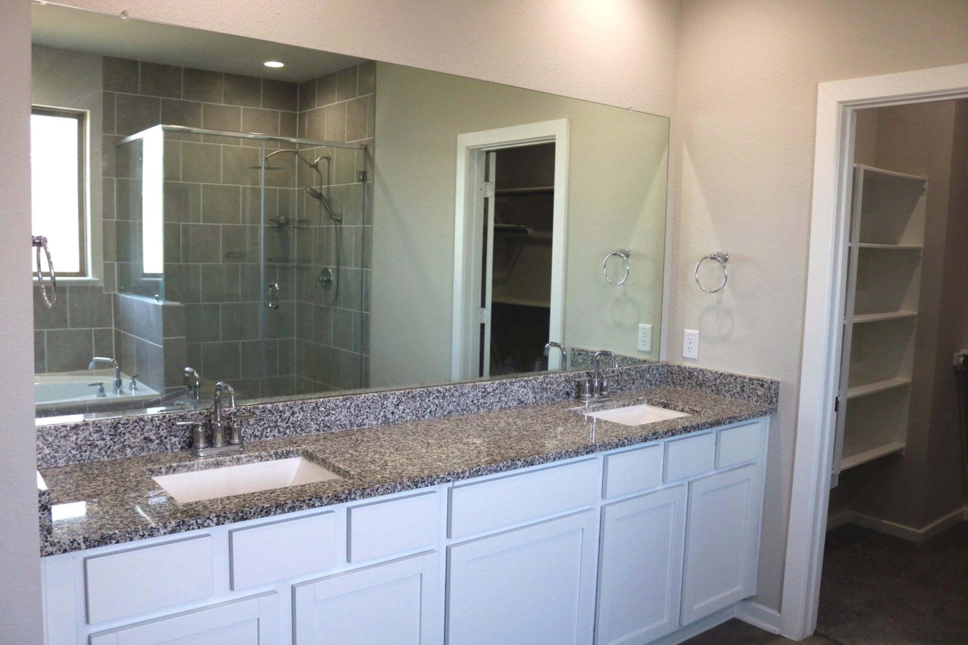 1007 Rosewood Trail, Beasley, TX 77417 Primary bath featuring two separate vanities with granite countertops, generous cabinet storage, and a large mirror, providing plenty of space for everyday routines.