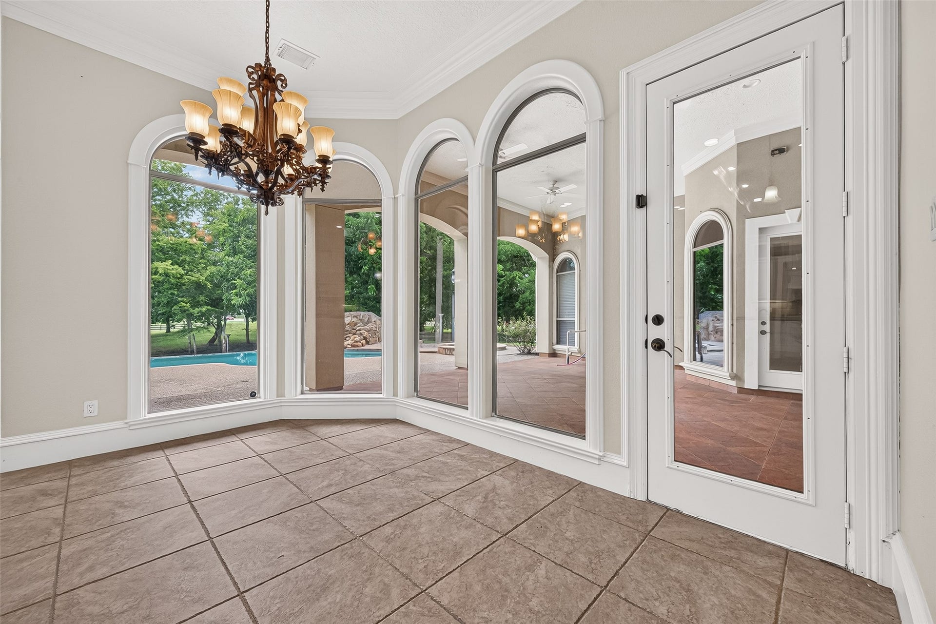 4011 Westerdale Drive, Fulshear, TX 77441 The breakfast nook is wrapped in natural light from the arched floor to ceiling windows that overlook the tranquil backyard.