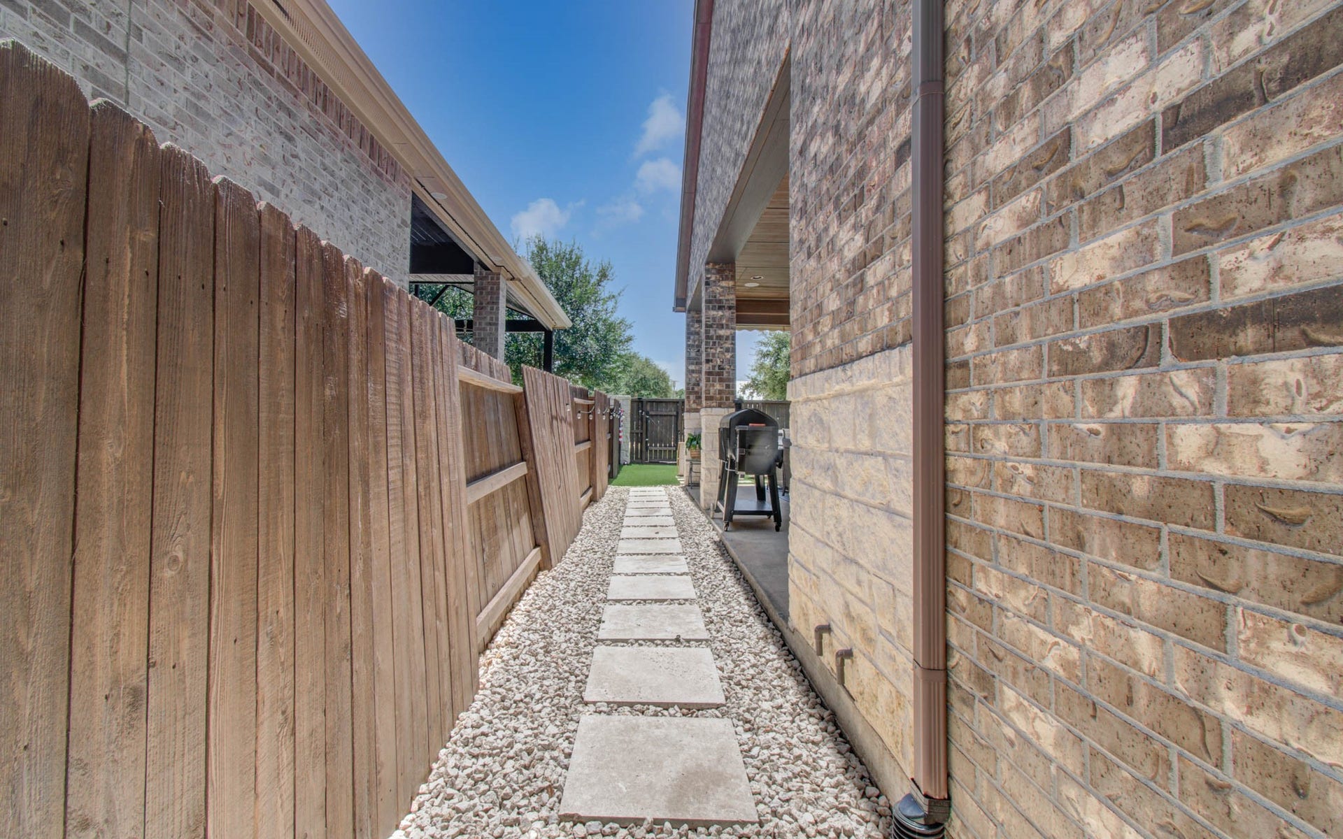 17915 Olde Oaks Estate Court, Cypress, TX 77433 Stone pathway alongside of home. Gutters routed underground to street for proper drainage.