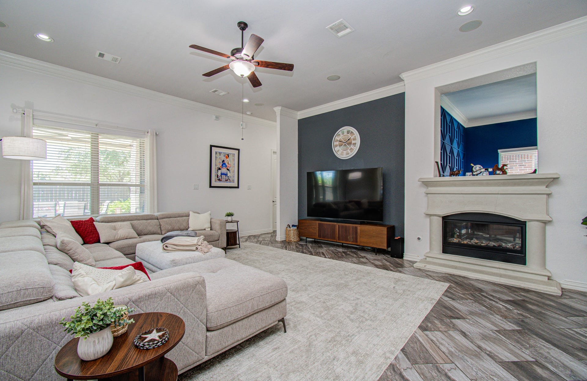 17915 Olde Oaks Estate Court, Cypress, TX 77433 Family room has wood tile flooring, double sided fireplace and accent wall for a designer look.