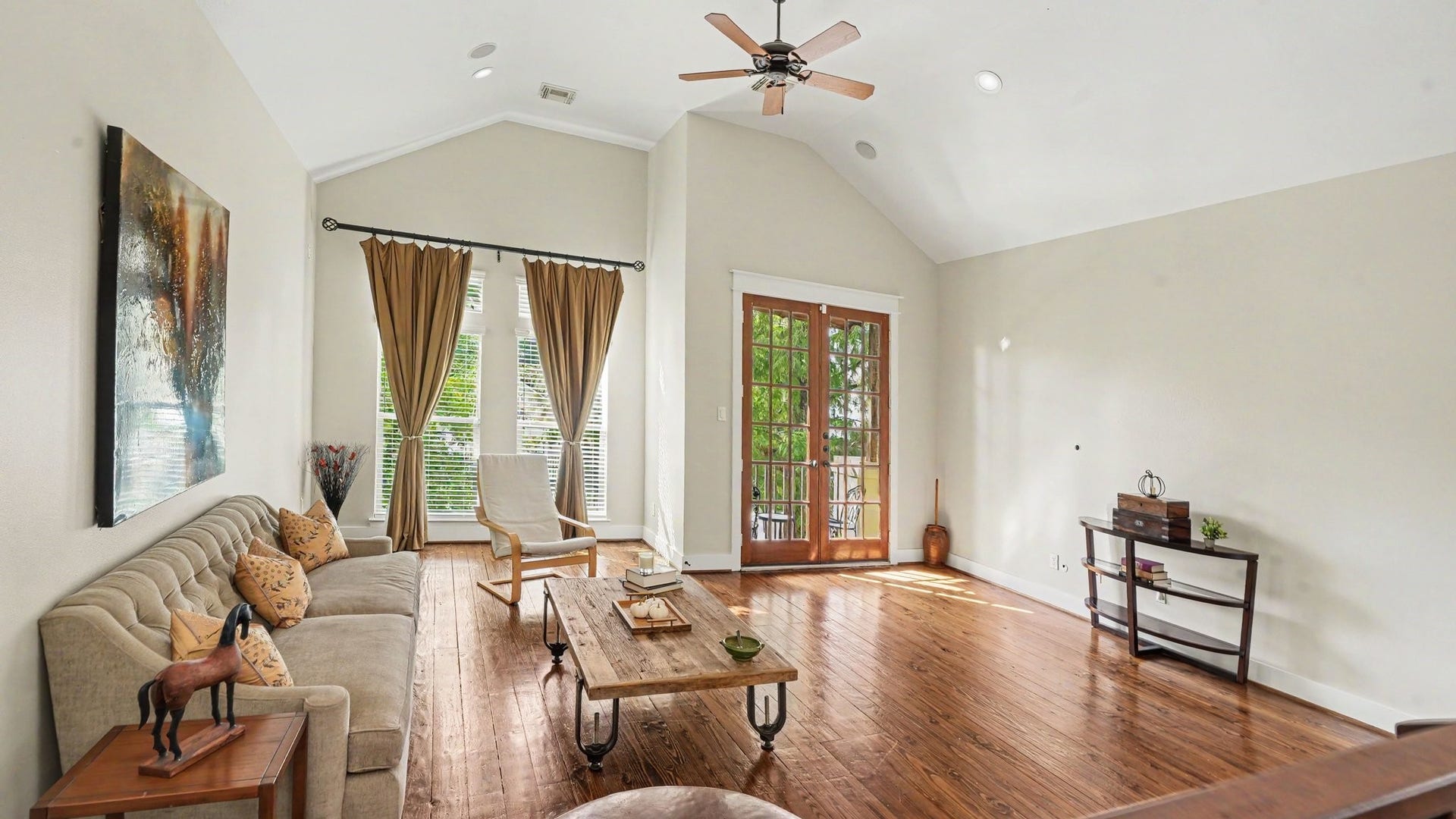 Beautiful and spacious living room lets in plenty of natural light, with high ceilings and real hardwood floors. French doors lead out to a private balcony overlooking the greenery of 2 mature trees.