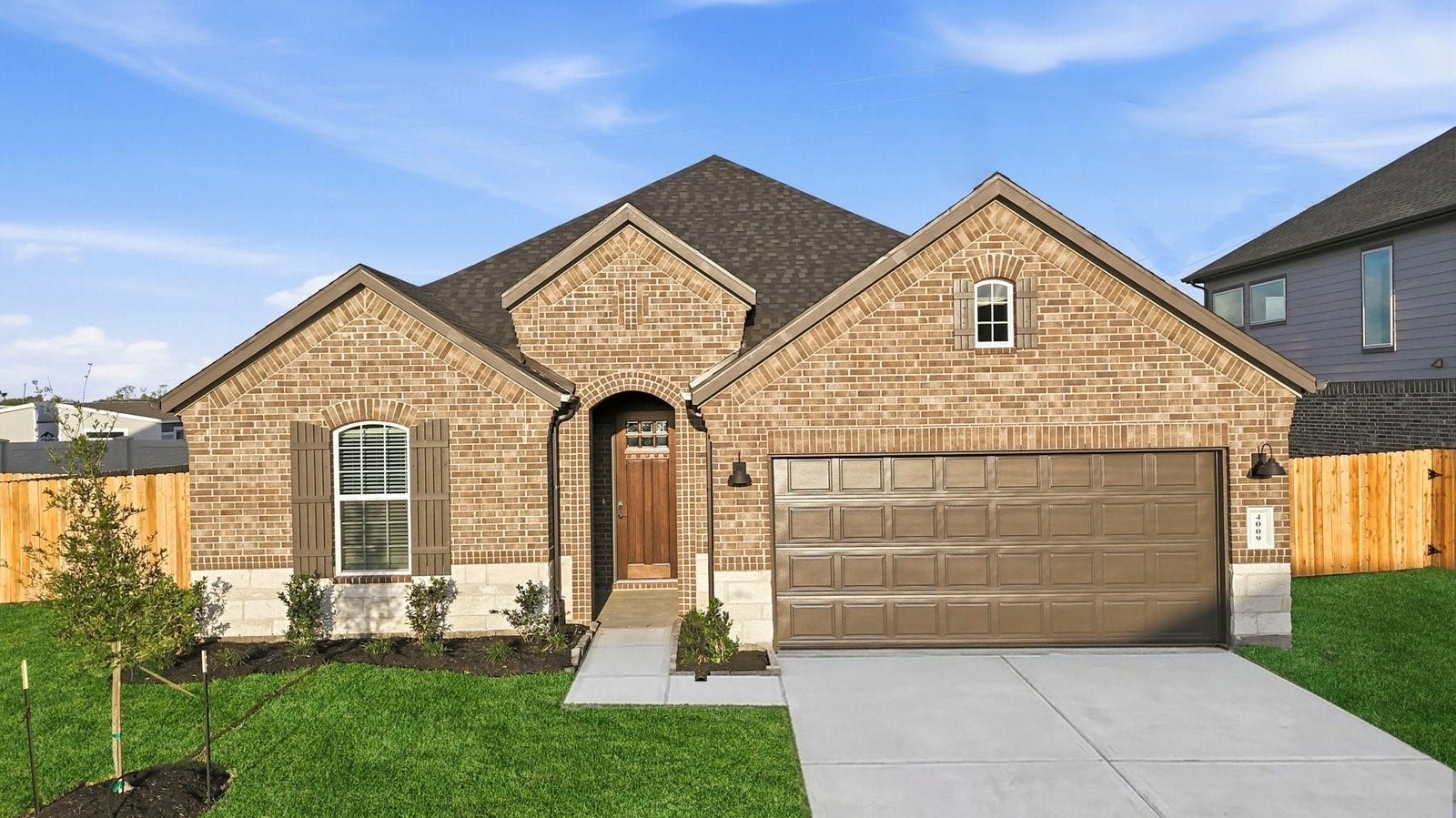 2307 Poseidon Street, League City, TX 77573 Newly built single story home with traditional architecture, a double garage, and landscaped front yard.