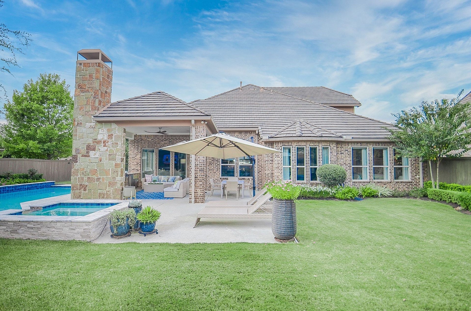 86 Quiet Way Lane, Sugar Land, TX 77498 Private backyard retreat features pool, spa, and expansive lawn with the covered patio for relaxing outdoors the four seasons of the year. Brick and stone details, a tile roof and generous windows comp0lete the home's inviting exterior.