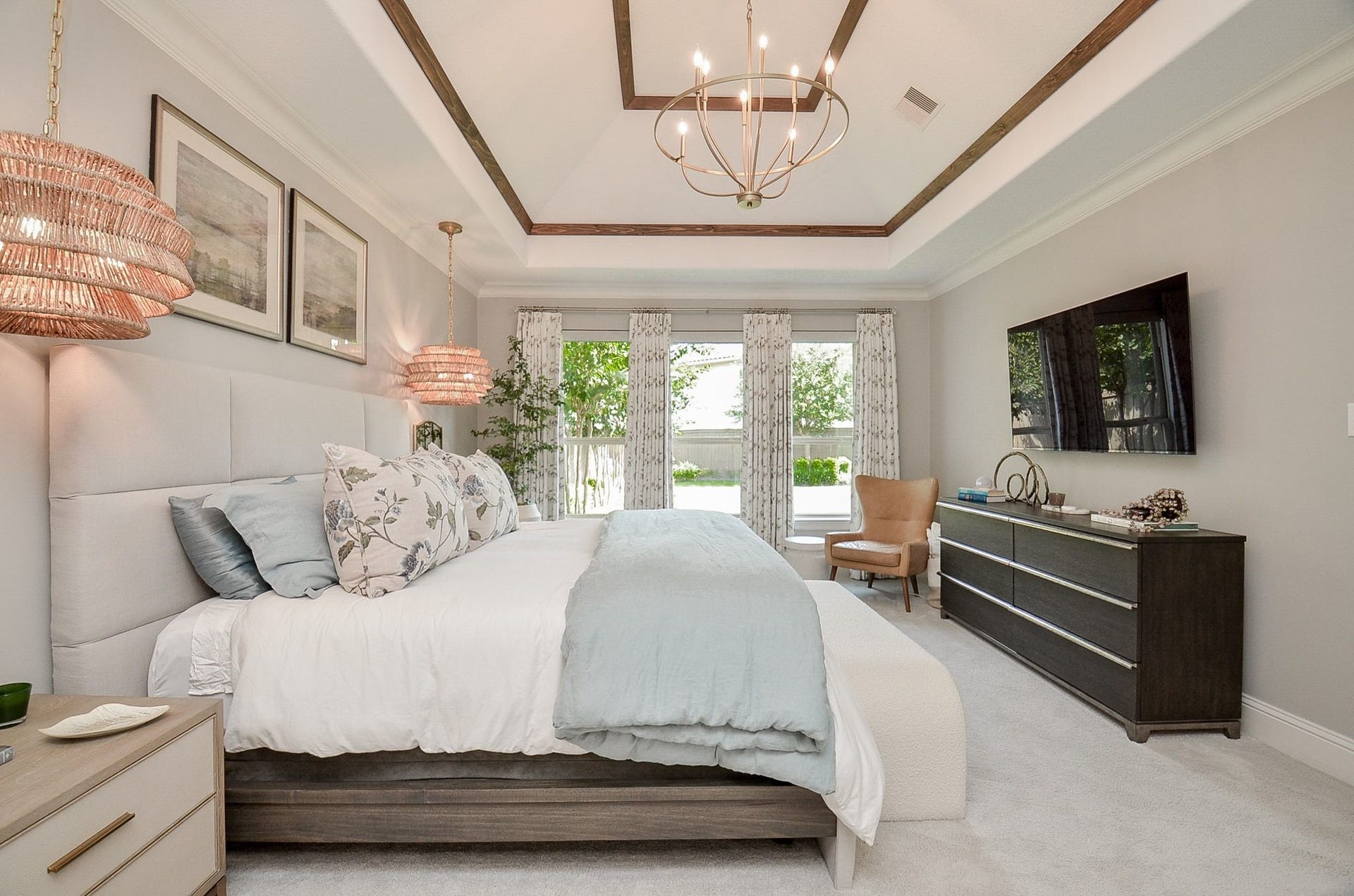 86 Quiet Way Lane, Sugar Land, TX 77498 Designed for elegance and comfort this serene primary suite, is beautifully finished with a wood-accented tray ceiling, statement chandelier, soft neutral tones, and abundant natural light