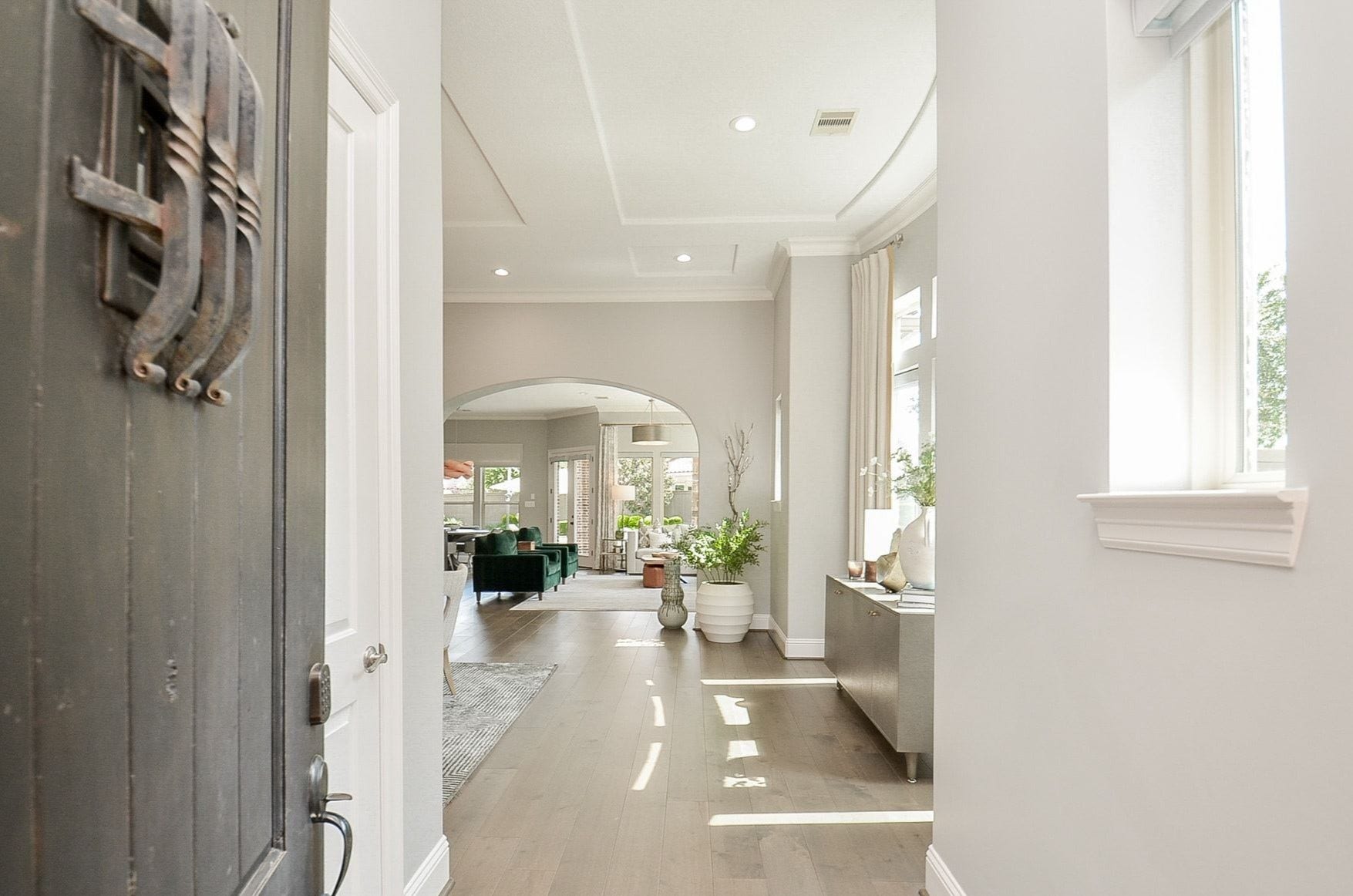 86 Quiet Way Lane, Sugar Land, TX 77498 Beautiful sightlines from the foyer showcase rich flooring, elegant ceiling details, arched openings, and a stunning wall of windows overlooking the backyard.
