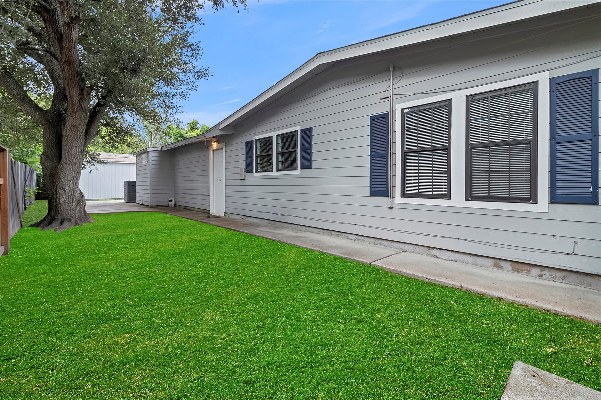 604 19th Avenue N, Texas City, TX 77590 Private side yard with plenty of green space, mature shade tree, and direct access around the home.