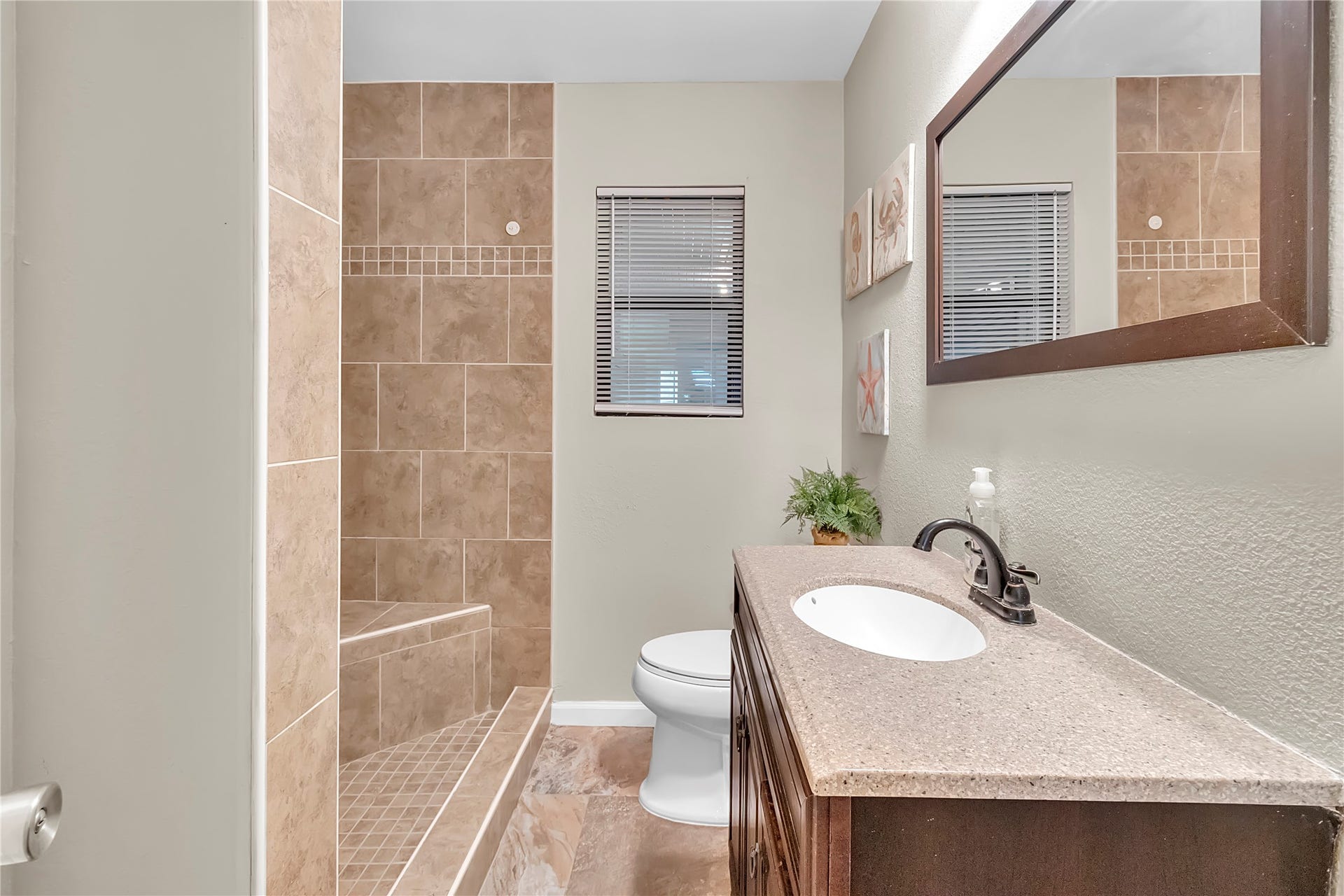 604 19th Avenue N, Texas City, TX 77590 Updated full bathroom with tiled shower surround, bright vanity area, and neutral finishes.