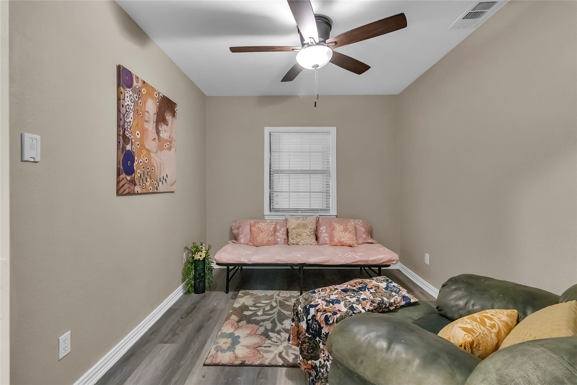 604 19th Avenue N, Texas City, TX 77590 Bright and spacious 2nd bedroom with vinyl wood flooring, ceiling fan, and a window overlooking the sunroom.