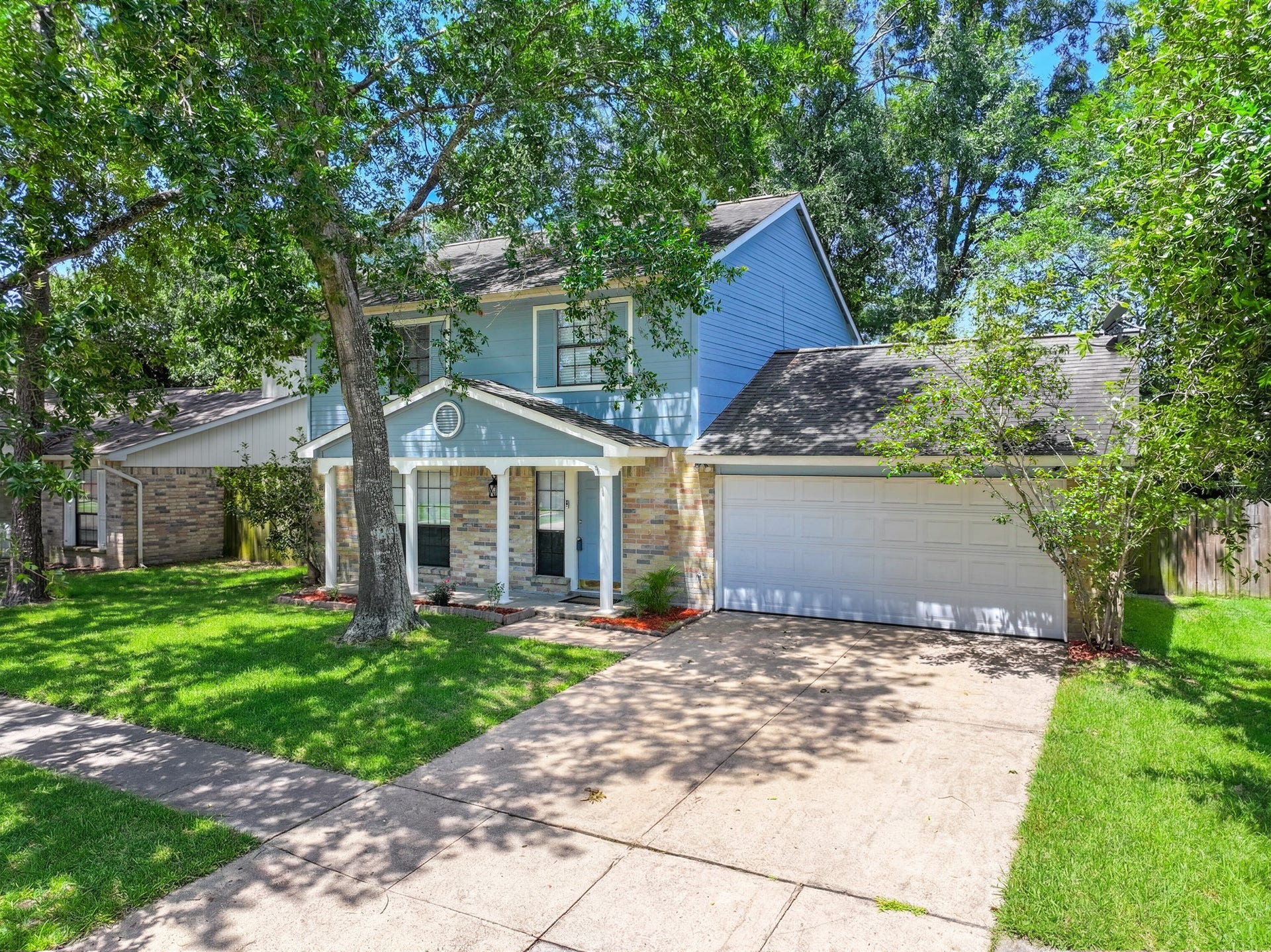 Charming curb appeal on this beautifully maintained 2-story home in the established Mill Creek community of Humble! Gray-blue vinyl siding paired with classic brick accents creates a timeless look, while the lush green lawn, red mulch beds, and mature shade trees make this home stand out on the block.
