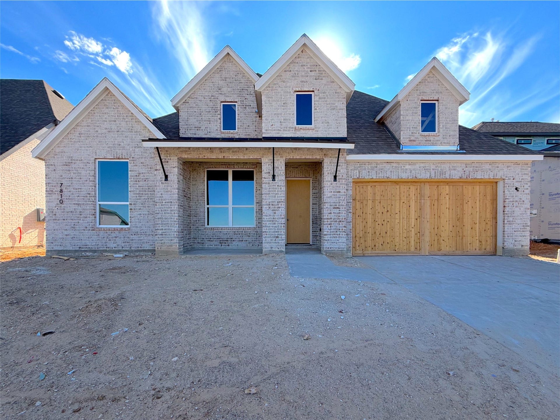 Beautiful Ozark smoke brick with timeless curb appeal and a welcoming covered front porch.