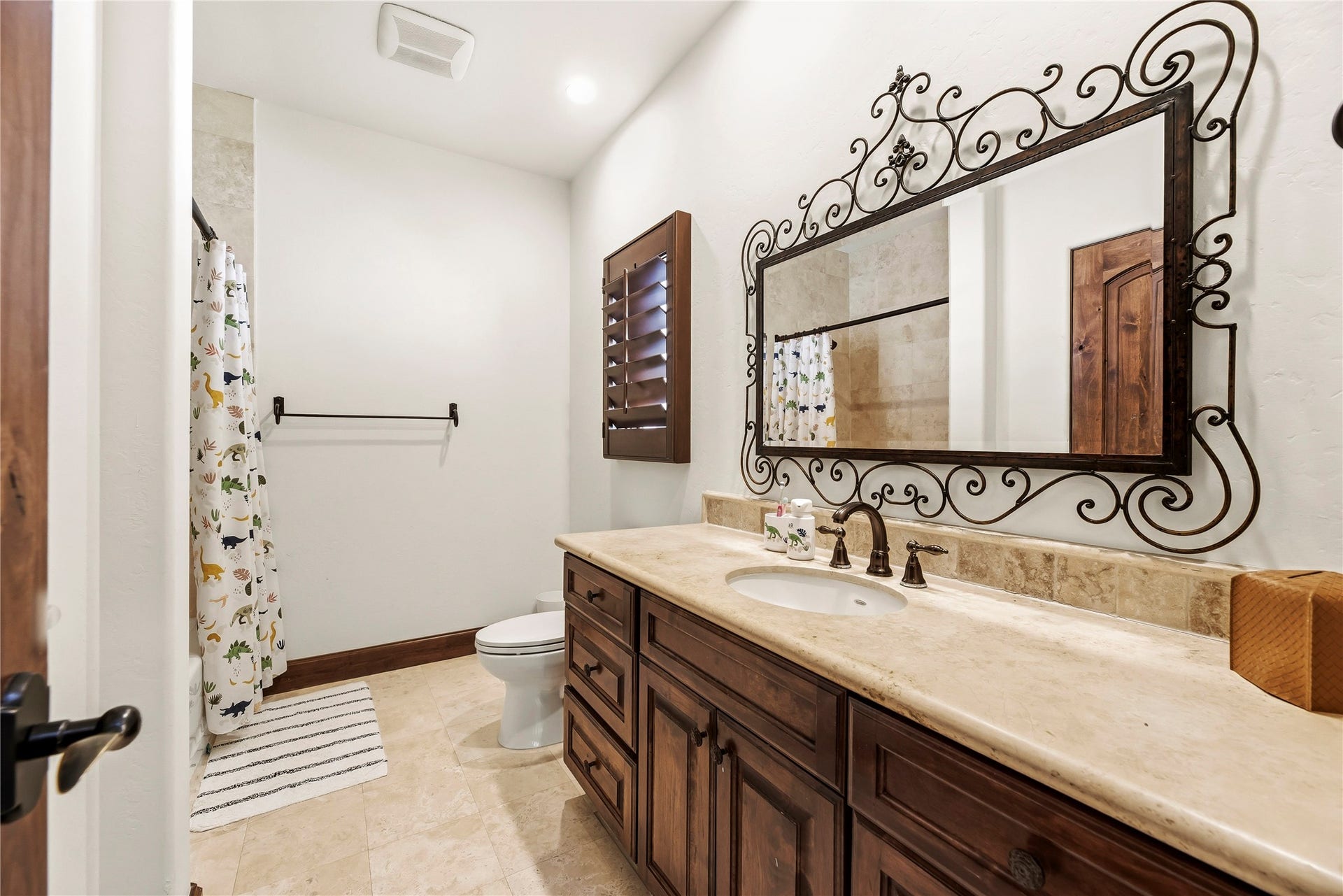 3803 Drake Street, Houston, TX 77005 The secondary bathroom features a custom wrought-iron mirror and granite vanity, ensuring even guest spaces are treated with refined elegance.