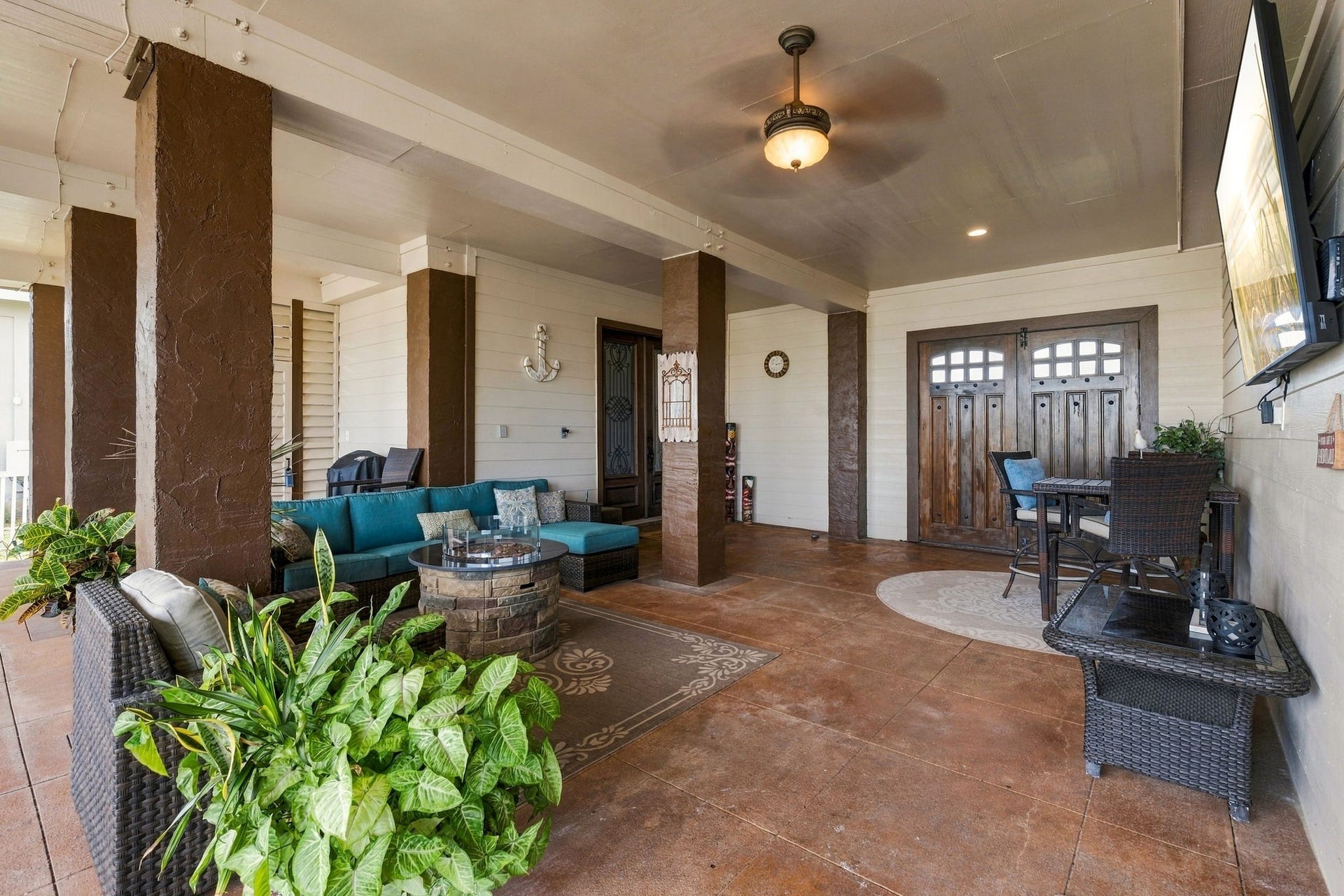 26 Half Moon, Hitchcock, TX 77563 Spacious covered patio with stylish seating, ceiling fan, and rustic wooden accents, perfect for outdoor relaxation and entertaining.