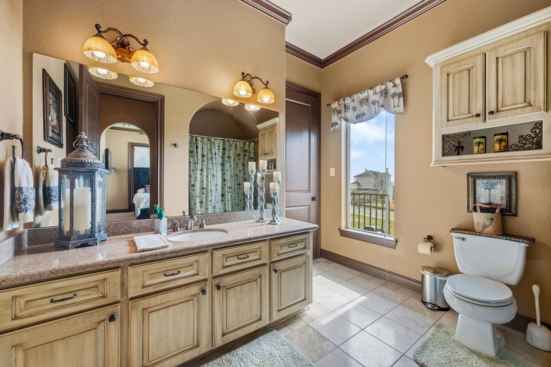 26 Half Moon, Hitchcock, TX 77563 Spacious Jack and Jill bathroom with dual sinks, warm lighting, and a spacious vanity, complemented by a large window offering natural light and scenic views.
