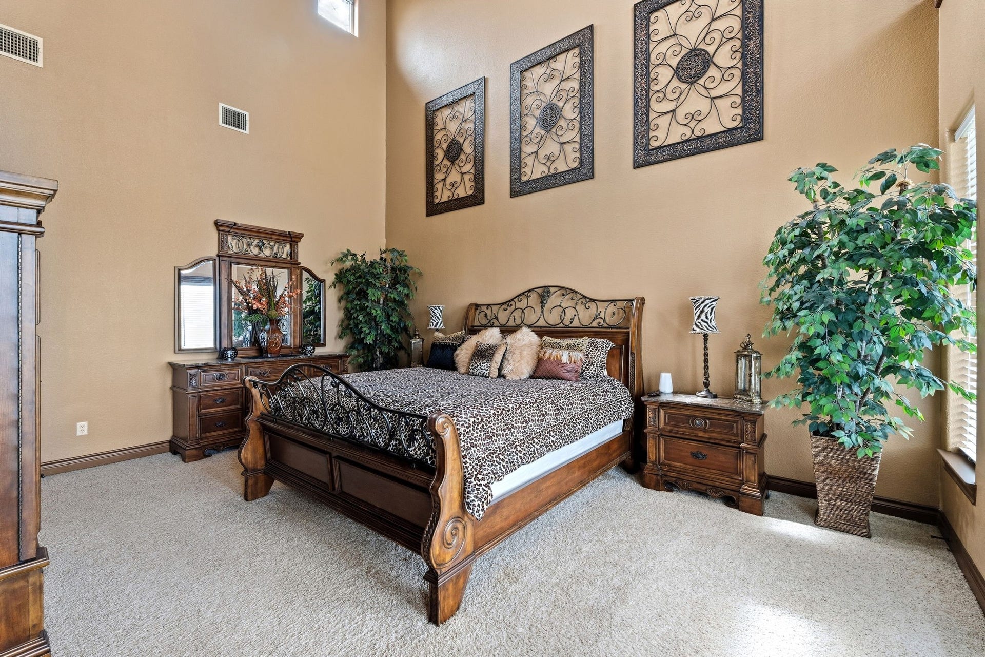 26 Half Moon, Hitchcock, TX 77563 Elegant primary bedroom featuring a high ceiling, rich wooden furniture, and large windows that fill the space with natural light.