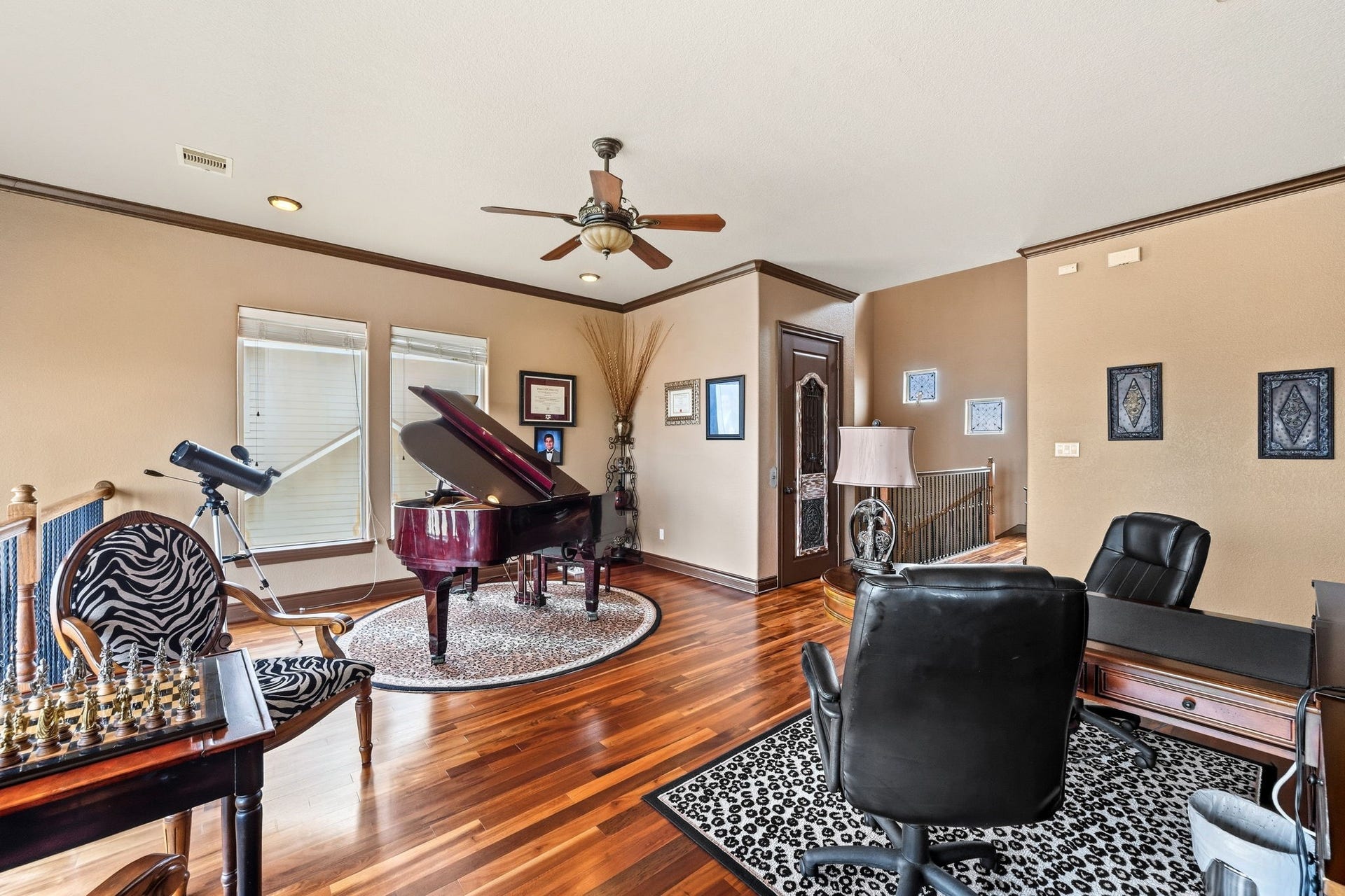 26 Half Moon, Hitchcock, TX 77563 Elegant study with rich hardwood floors, featuring a grand piano and a cozy seating area, perfect for relaxation or creative pursuits.