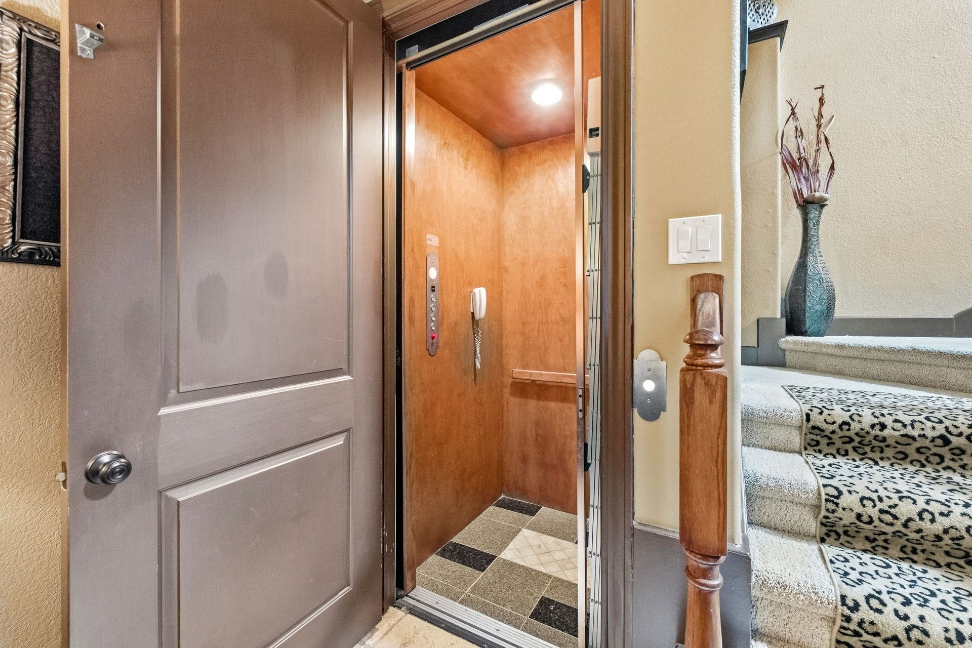 26 Half Moon, Hitchcock, TX 77563 Elegant home featuring a convenient in-house elevator adjacent to a stylish staircase with leopard print carpeting.