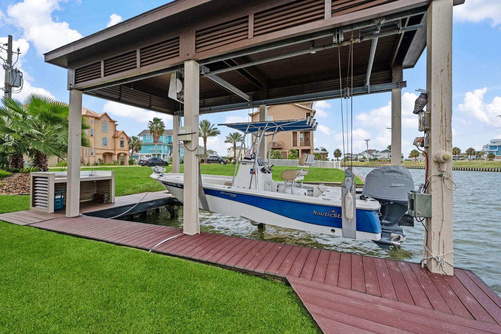 26 Half Moon, Hitchcock, TX 77563 Charming waterfront property features a covered boat lift on a serene canal, providing easy access for boating enthusiasts.