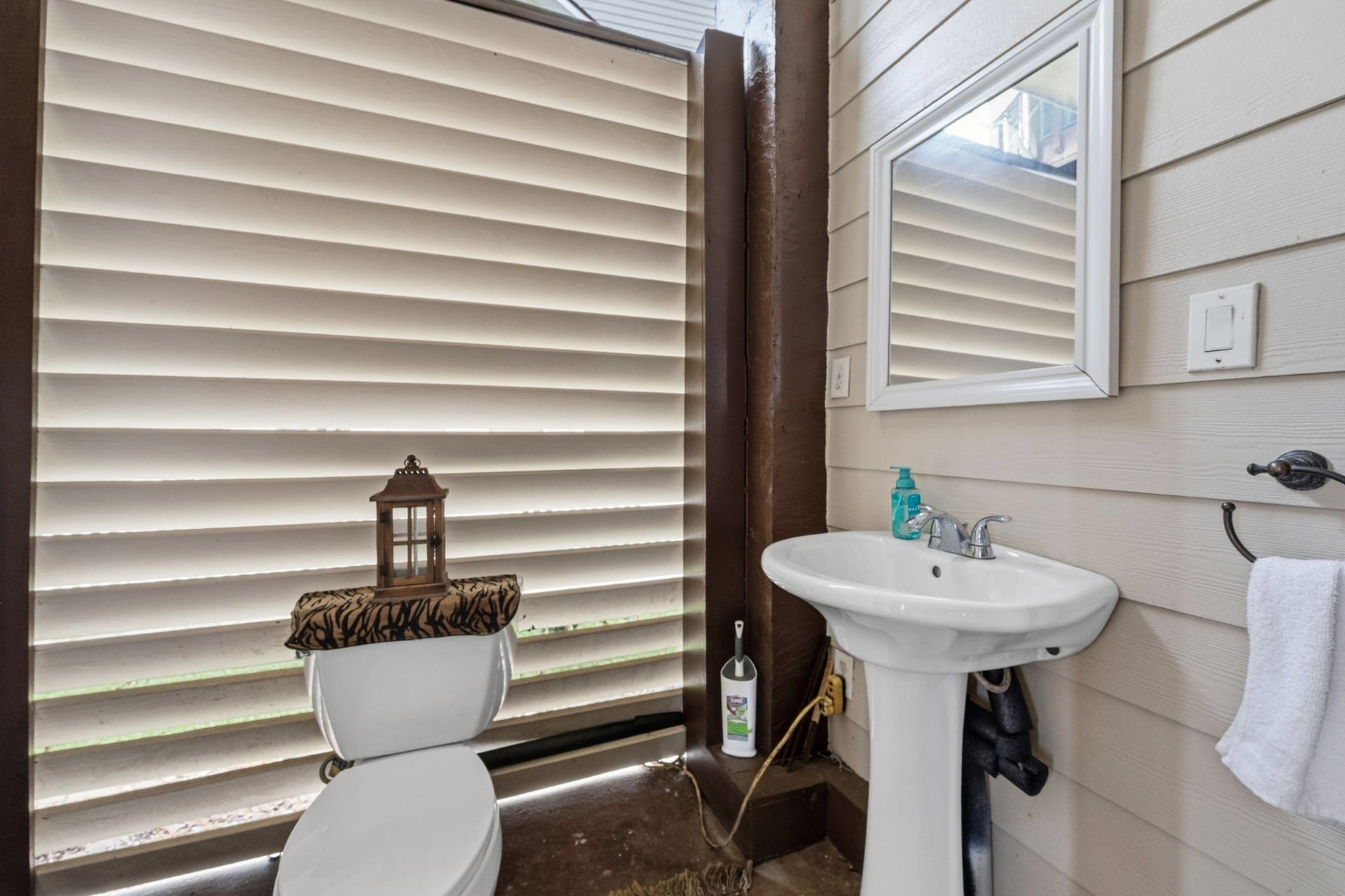 26 Half Moon, Hitchcock, TX 77563 Charming outdoor bathroom with privacy shutters, featuring a pedestal sink and stylish accents.