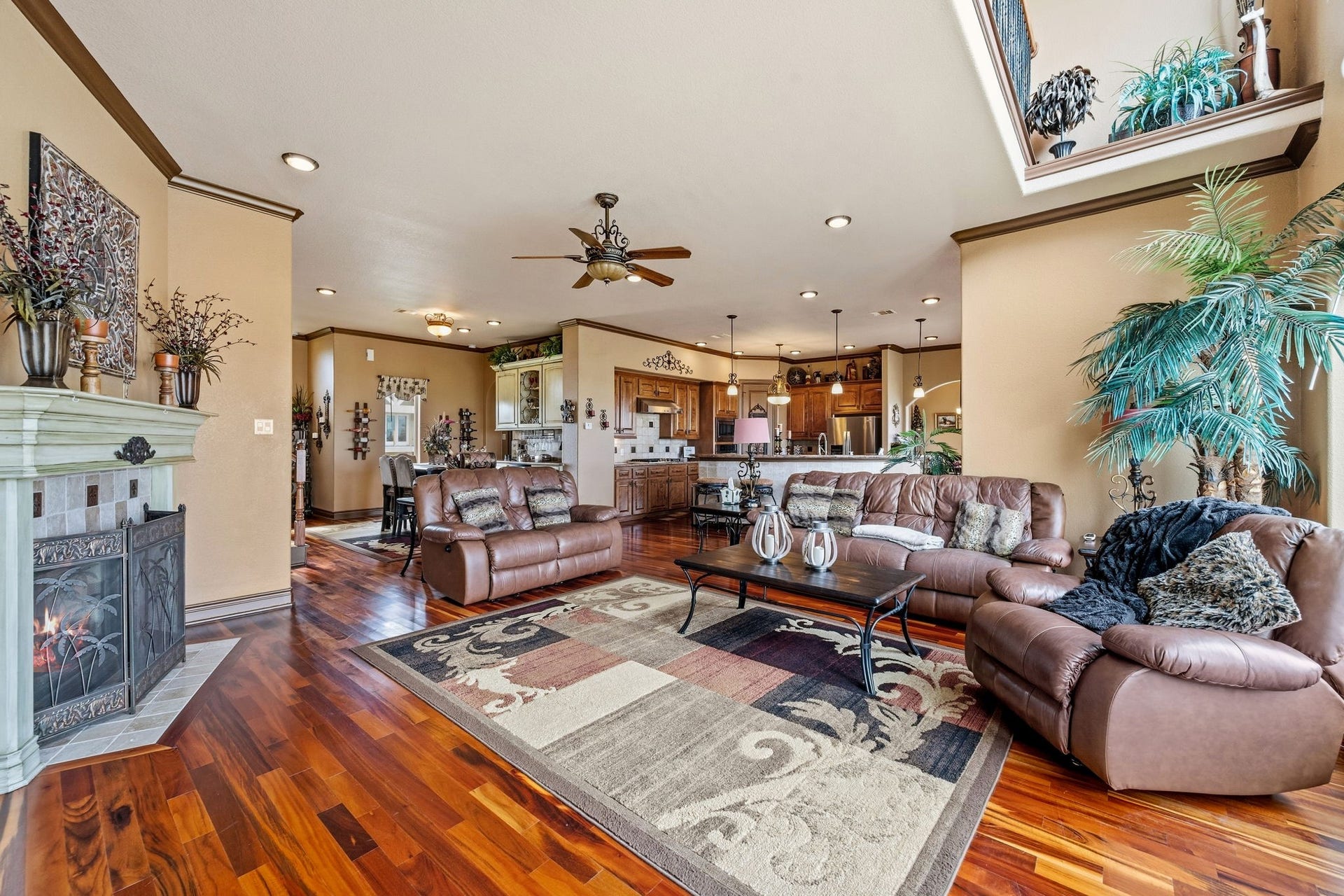 26 Half Moon, Hitchcock, TX 77563 Spacious living area with rich wood flooring, cozy fireplace, and ample natural light, seamlessly connecting to a modern kitchen and dining space.