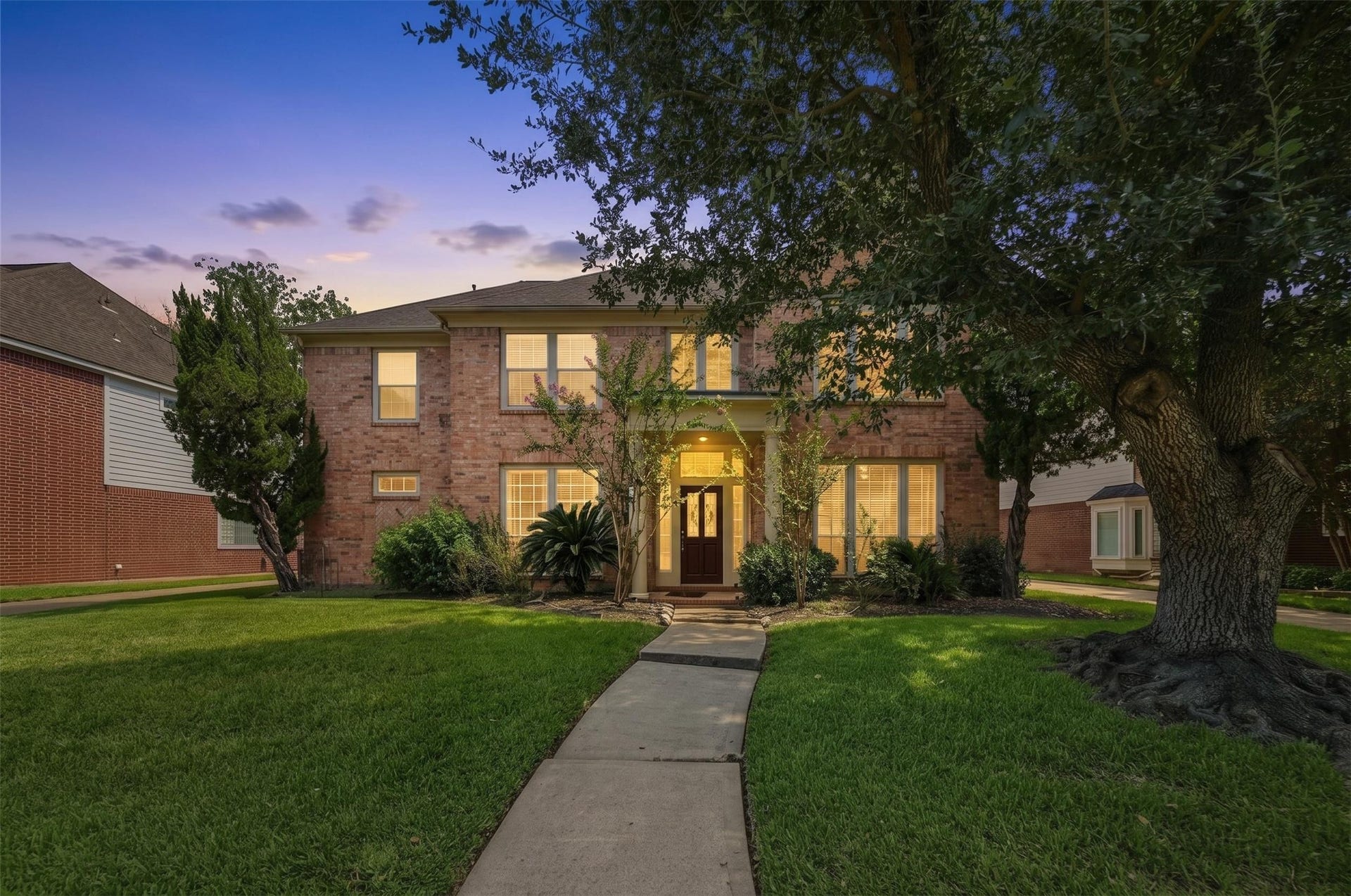 4907 Cambridge Street, Sugar Land, TX 77479 The front of the home has gorgeous greenery and shows off the many windows. Virtually enhanced.