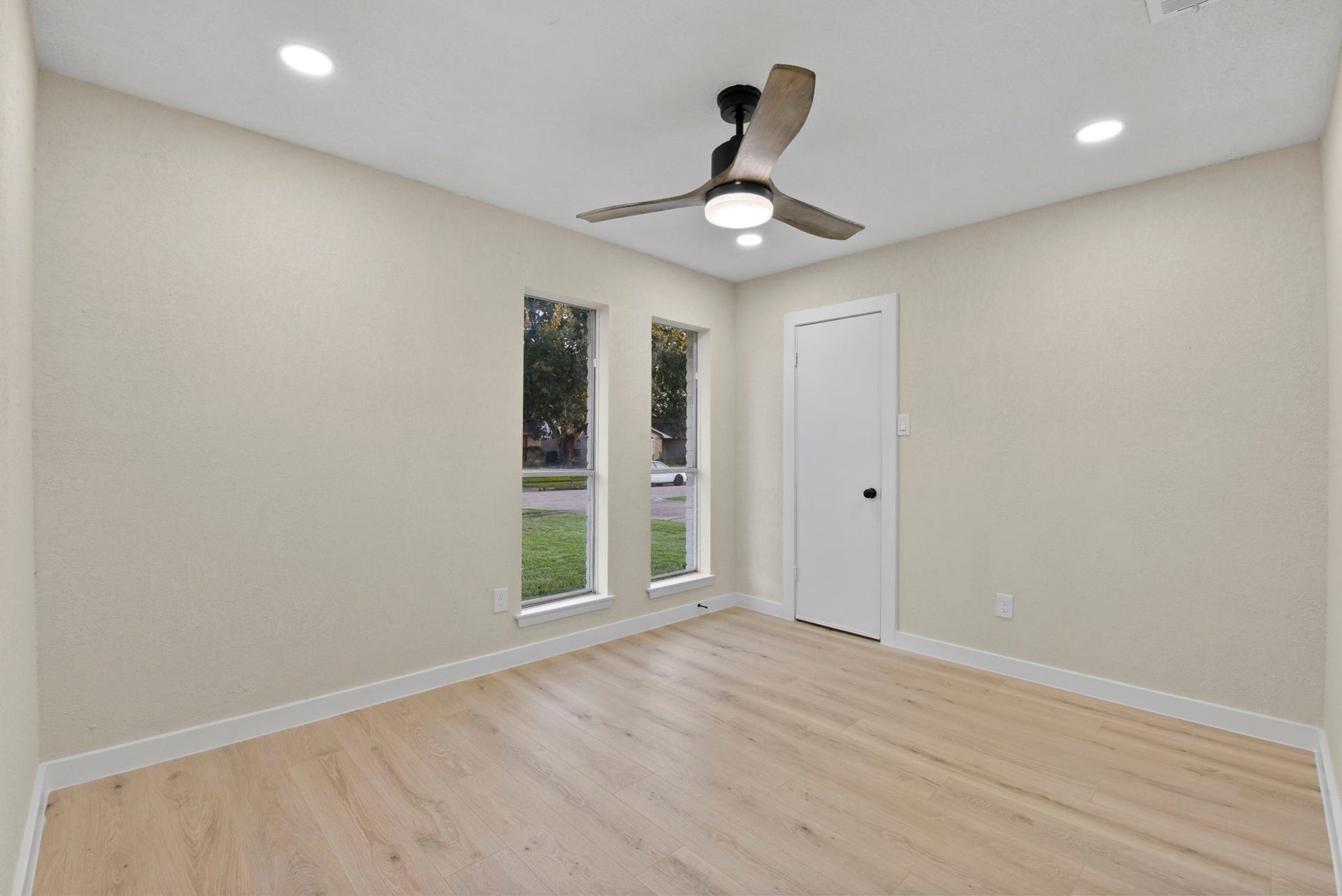 2322 Aprilmont Drive, Sugar Land, TX 77498 Bright and inviting room featuring sleek wood flooring, recessed lighting, and a modern ceiling fan, complemented by two large windows for natural light.