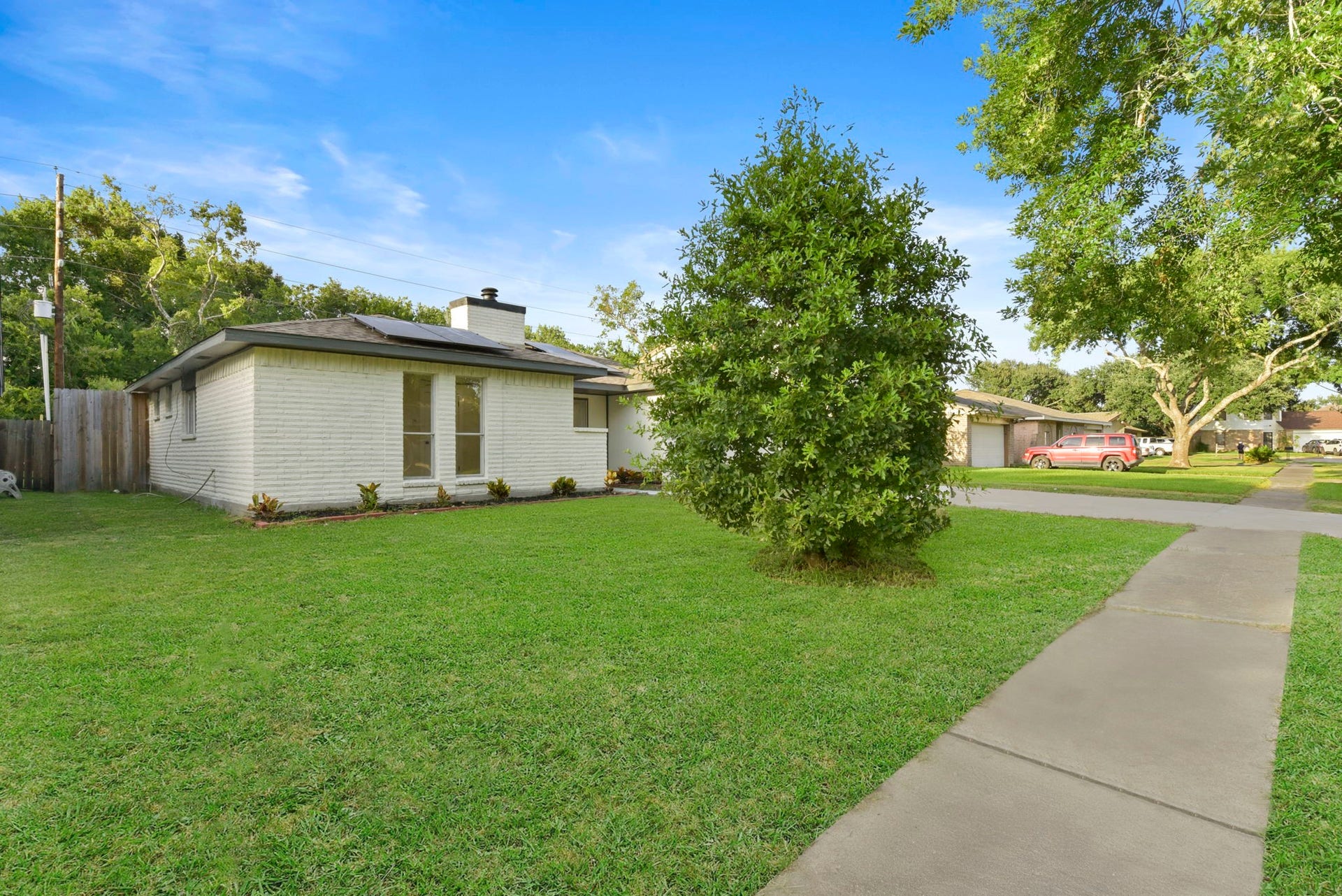 2322 Aprilmont Drive, Sugar Land, TX 77498 Charming single-story home with a spacious front yard and mature trees, offering a welcoming and serene atmosphere.