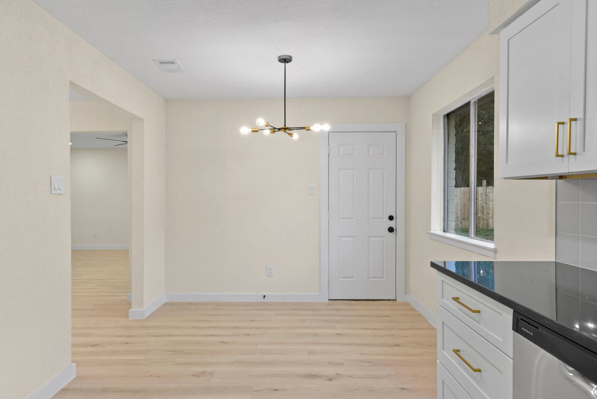 2322 Aprilmont Drive, Sugar Land, TX 77498 Bright dining area with sleek hardwood floors, modern light fixture, and convenient access to the backyard through a stylish door.