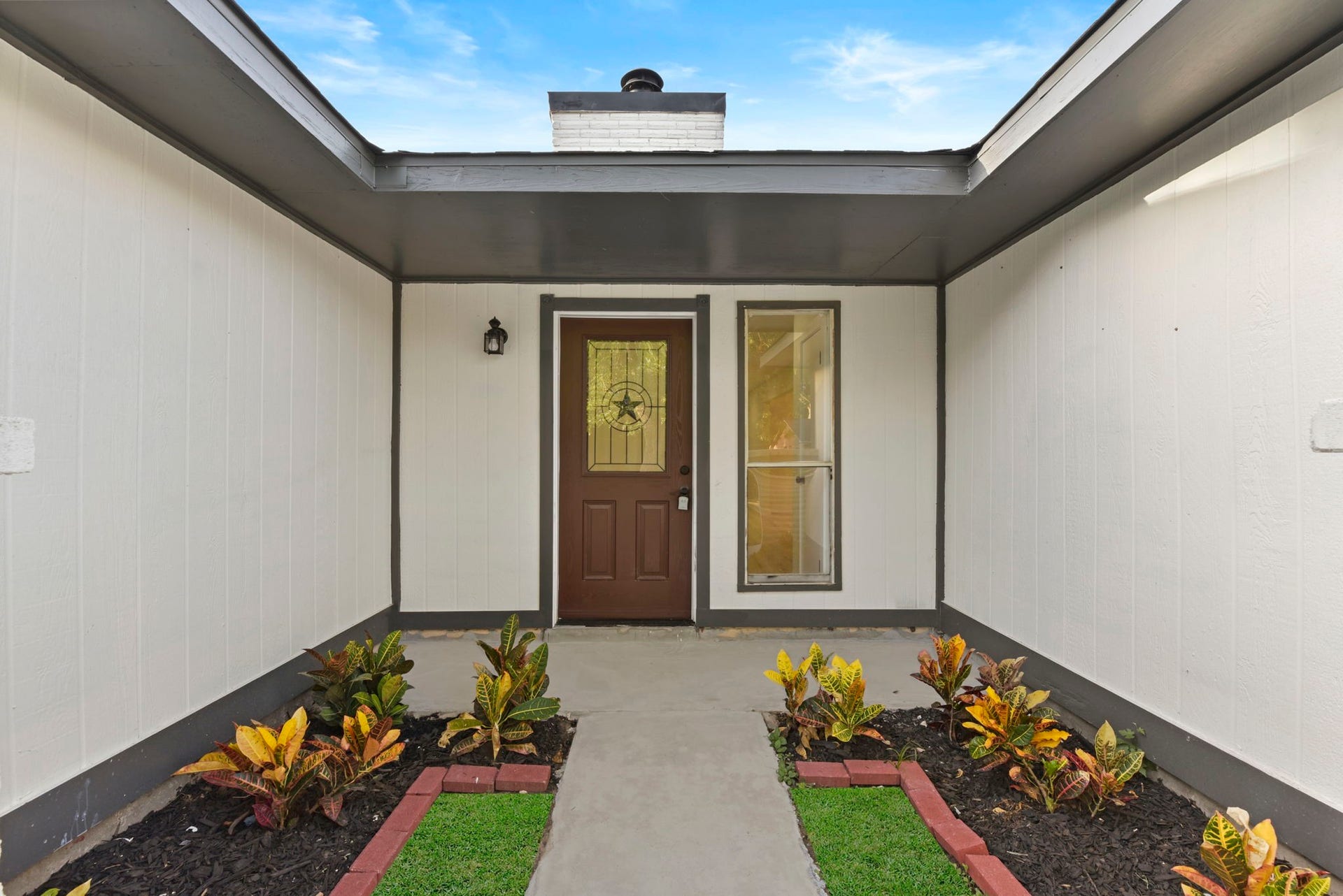 2322 Aprilmont Drive, Sugar Land, TX 77498 Inviting entryway with a charming brown door, elegant sidelights, and a neatly landscaped walkway featuring vibrant plants.