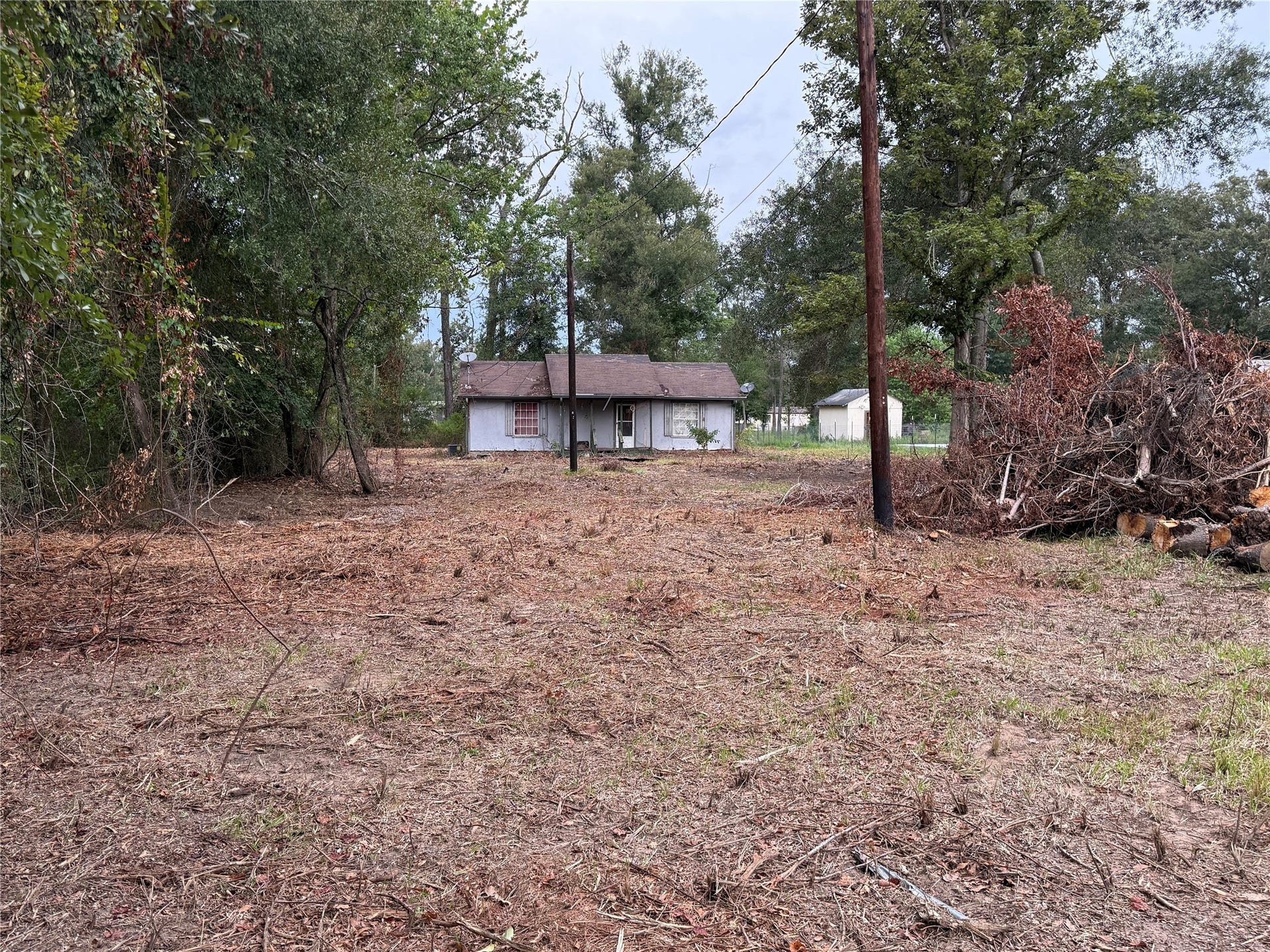 26331 Long Street, Splendora, TX 77372 Cleared 0.92-acre property with existing improvements and partially wooded surroundings.