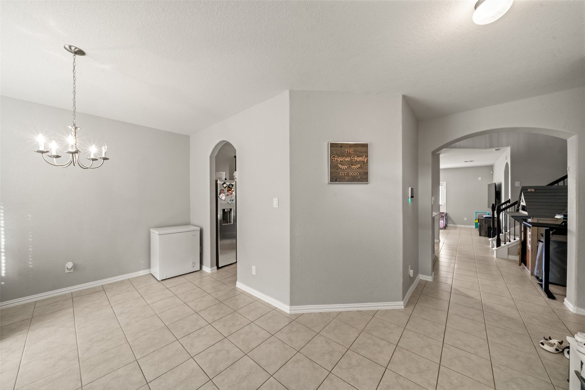 4509 Whitehaven Pine Way, Rosharon, TX 77583 Bright and spacious dining area with elegant chandelier lighting, tile flooring, and convenient access to the kitchen and living spaces through arched doorways.