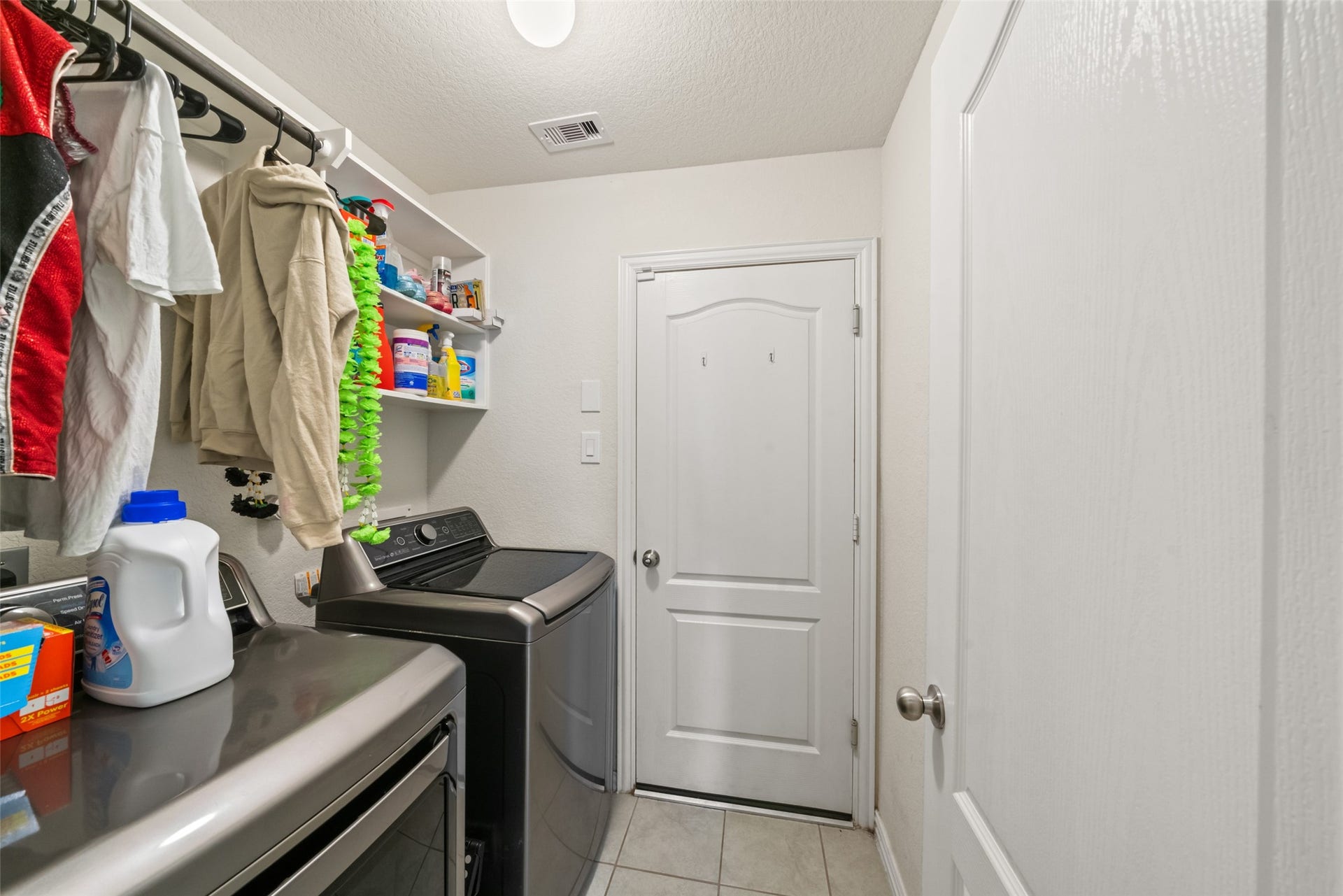 4509 Whitehaven Pine Way, Rosharon, TX 77583 Efficient laundry room with modern appliances, ample shelving for organization, and hanging space for clothes.