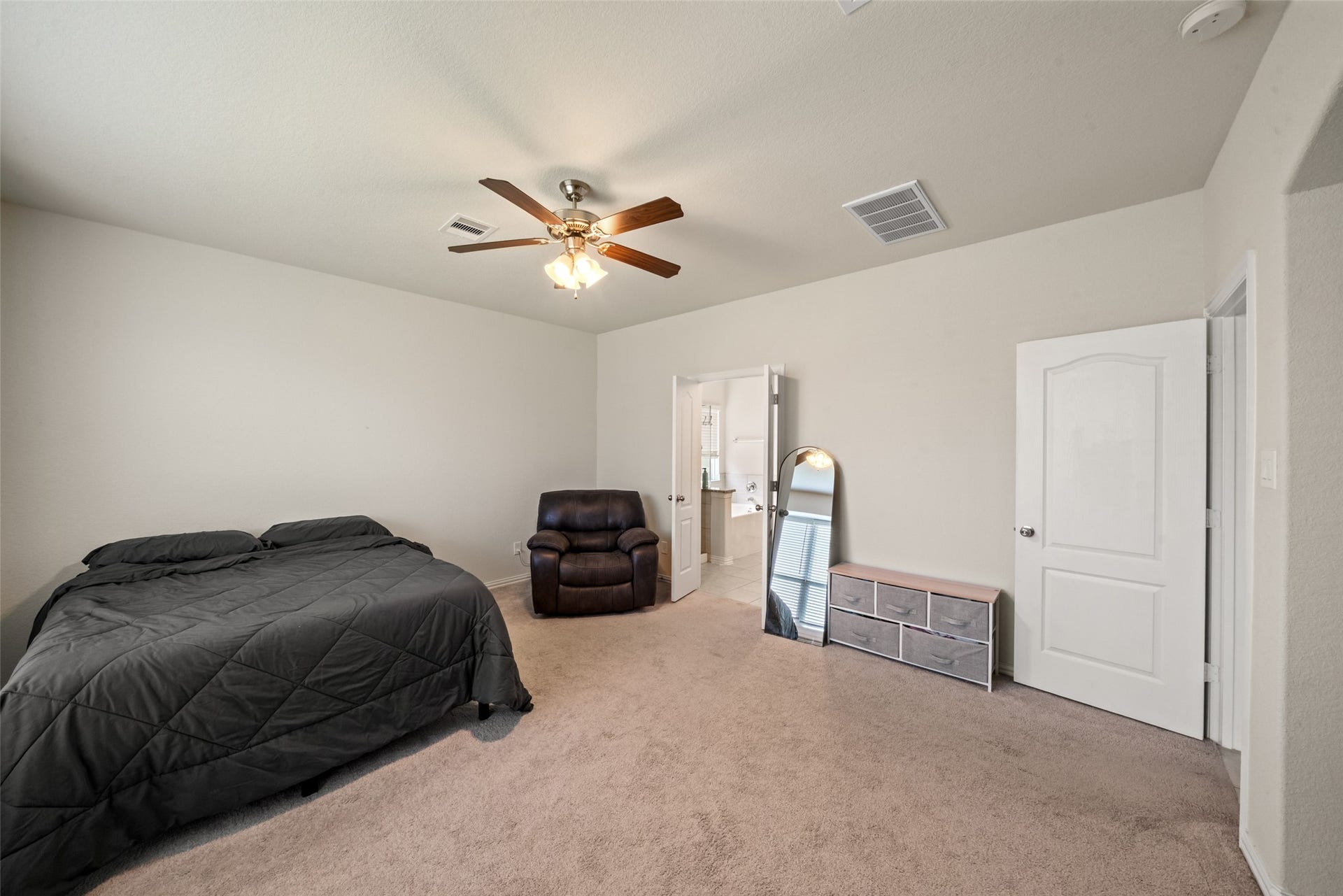 4509 Whitehaven Pine Way, Rosharon, TX 77583 Spacious bedroom featuring plush carpeting, a ceiling fan, and an en-suite bathroom for added convenience.