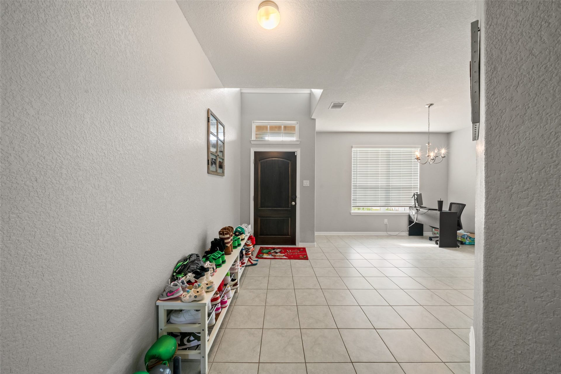 4509 Whitehaven Pine Way, Rosharon, TX 77583 Bright and welcoming entryway with tiled flooring, leading to a spacious room perfect for an office or additional living space, enhanced by a large window.