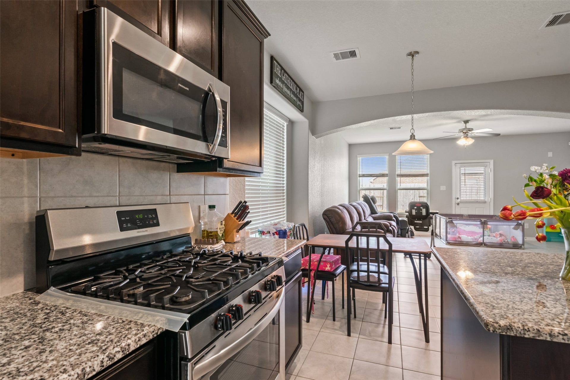 4509 Whitehaven Pine Way, Rosharon, TX 77583 Modern kitchen with sleek stainless steel appliances, granite countertops, and an open layout that flows into a cozy living area.