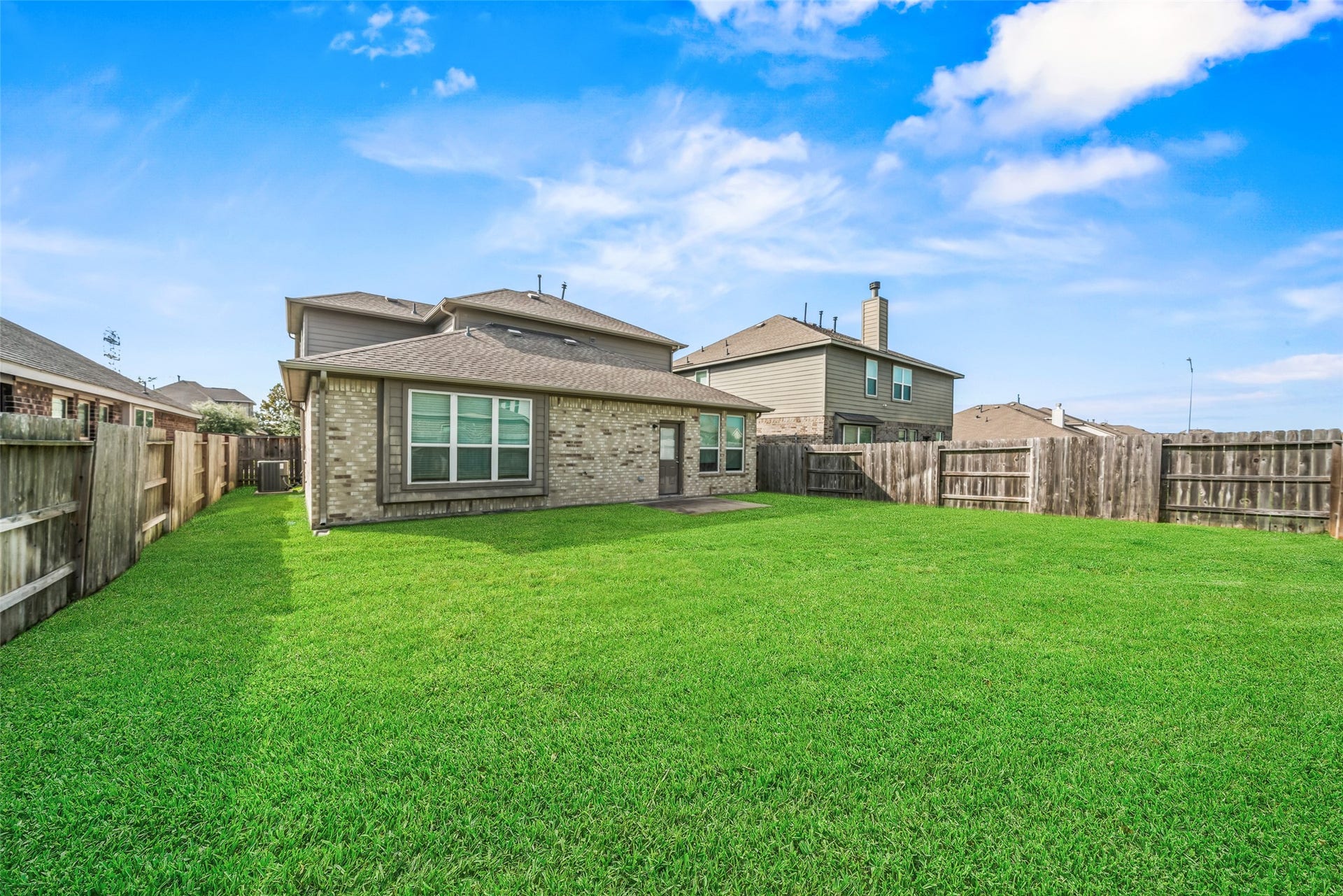 4509 Whitehaven Pine Way, Rosharon, TX 77583 Spacious backyard with lush green lawn, perfect for outdoor activities and relaxation, enclosed by a wooden fence for added privacy.