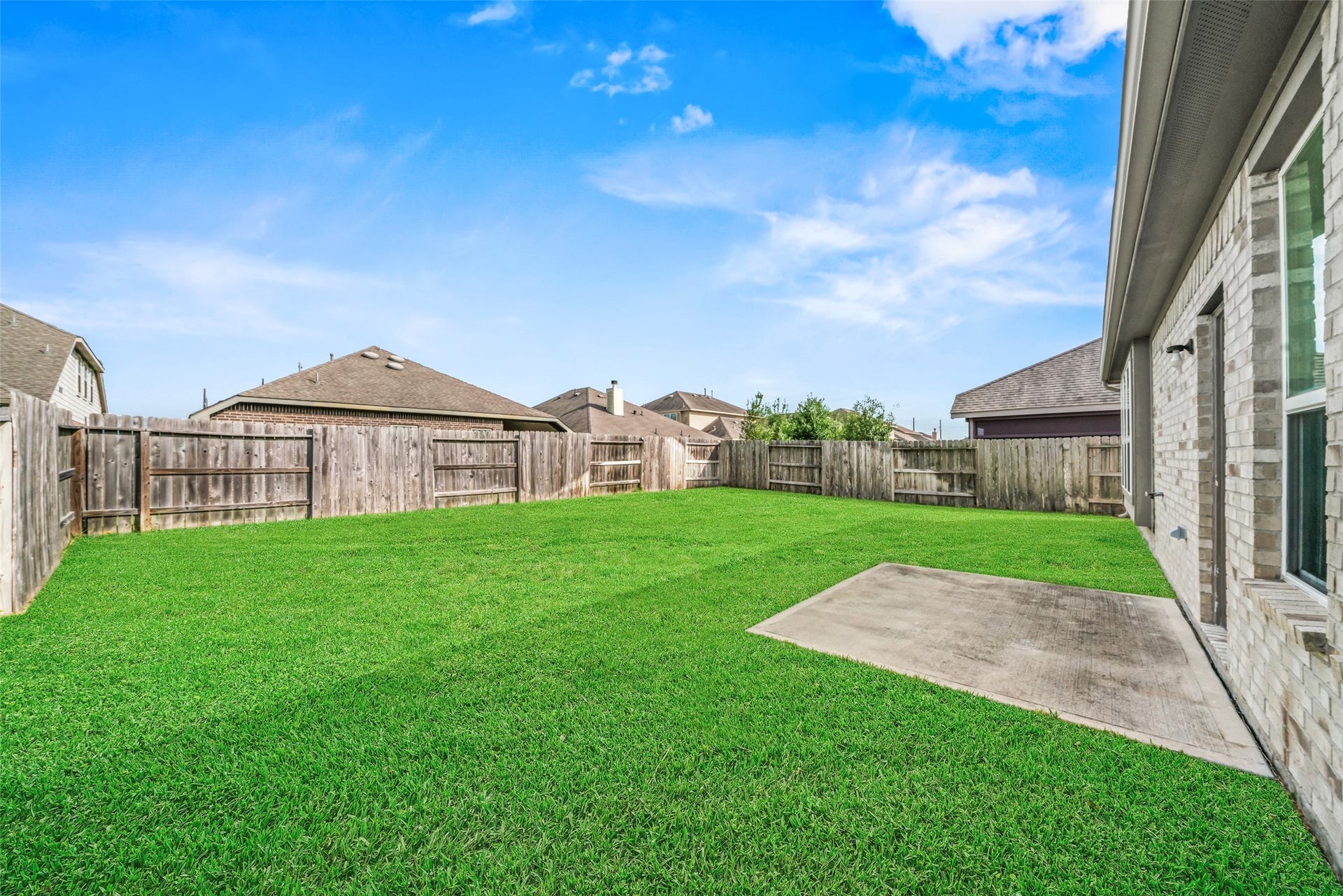 4509 Whitehaven Pine Way, Rosharon, TX 77583 Spacious backyard with lush green lawn, bordered by a wooden fence, perfect for outdoor activities and relaxation.