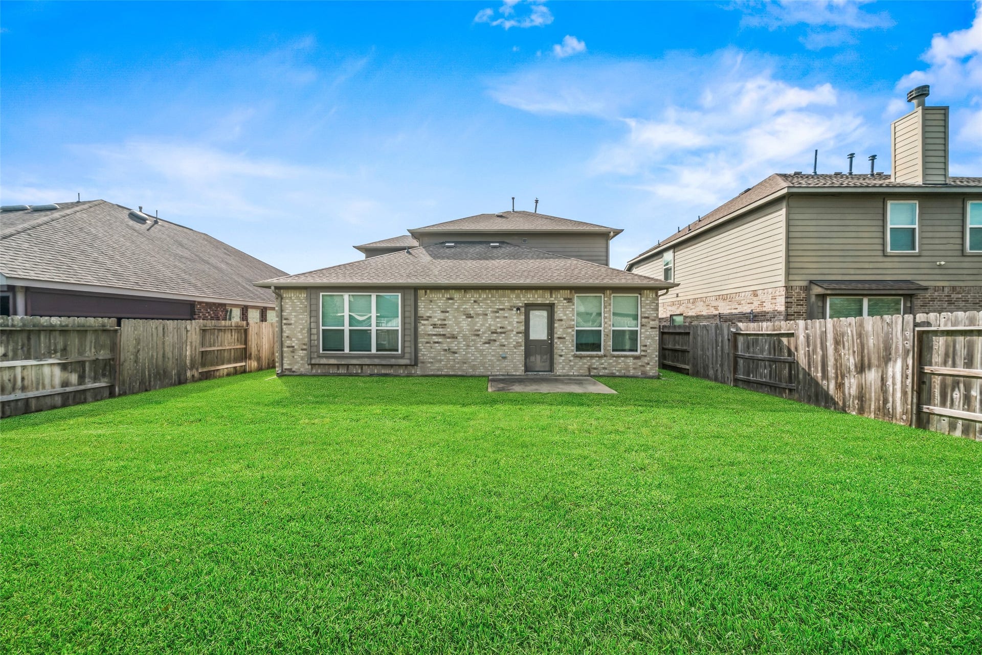 4509 Whitehaven Pine Way, Rosharon, TX 77583 Spacious backyard with lush green lawn, bordered by a sturdy wooden fence, perfect for outdoor activities and relaxation.