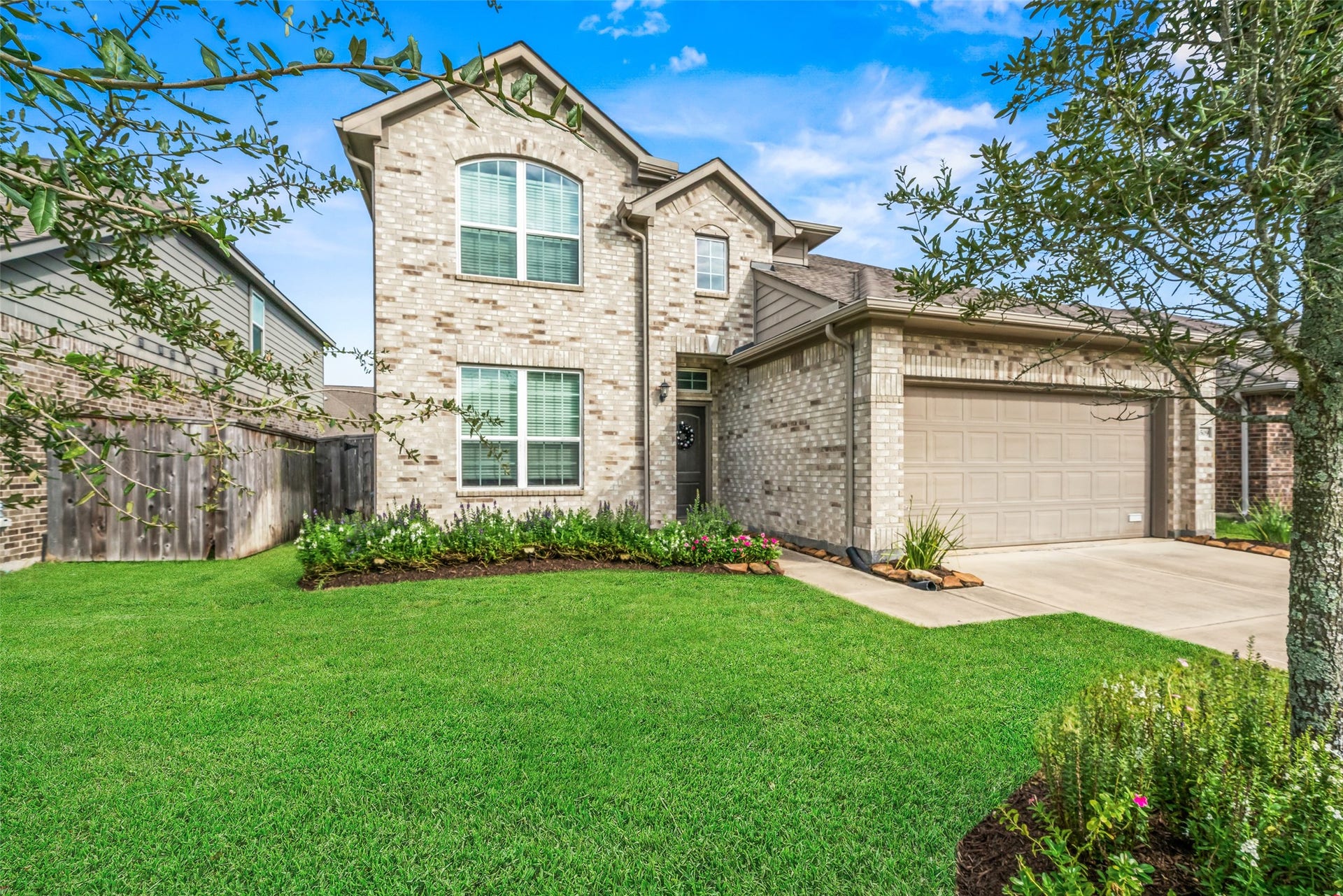 4509 Whitehaven Pine Way, Rosharon, TX 77583 Charming two-story brick home with a neatly landscaped front yard and a spacious two-car garage.