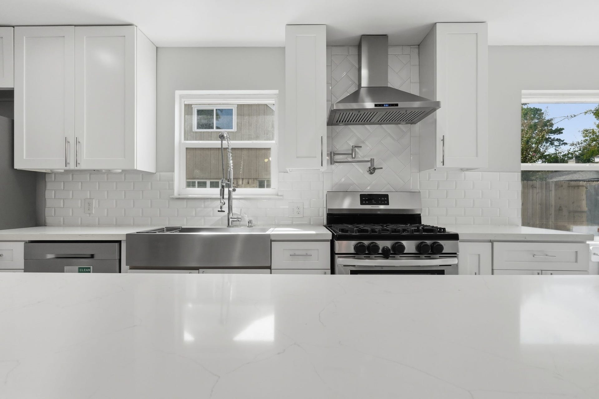 The kitchen features a large farmhouse sink with subway tile backsplash.