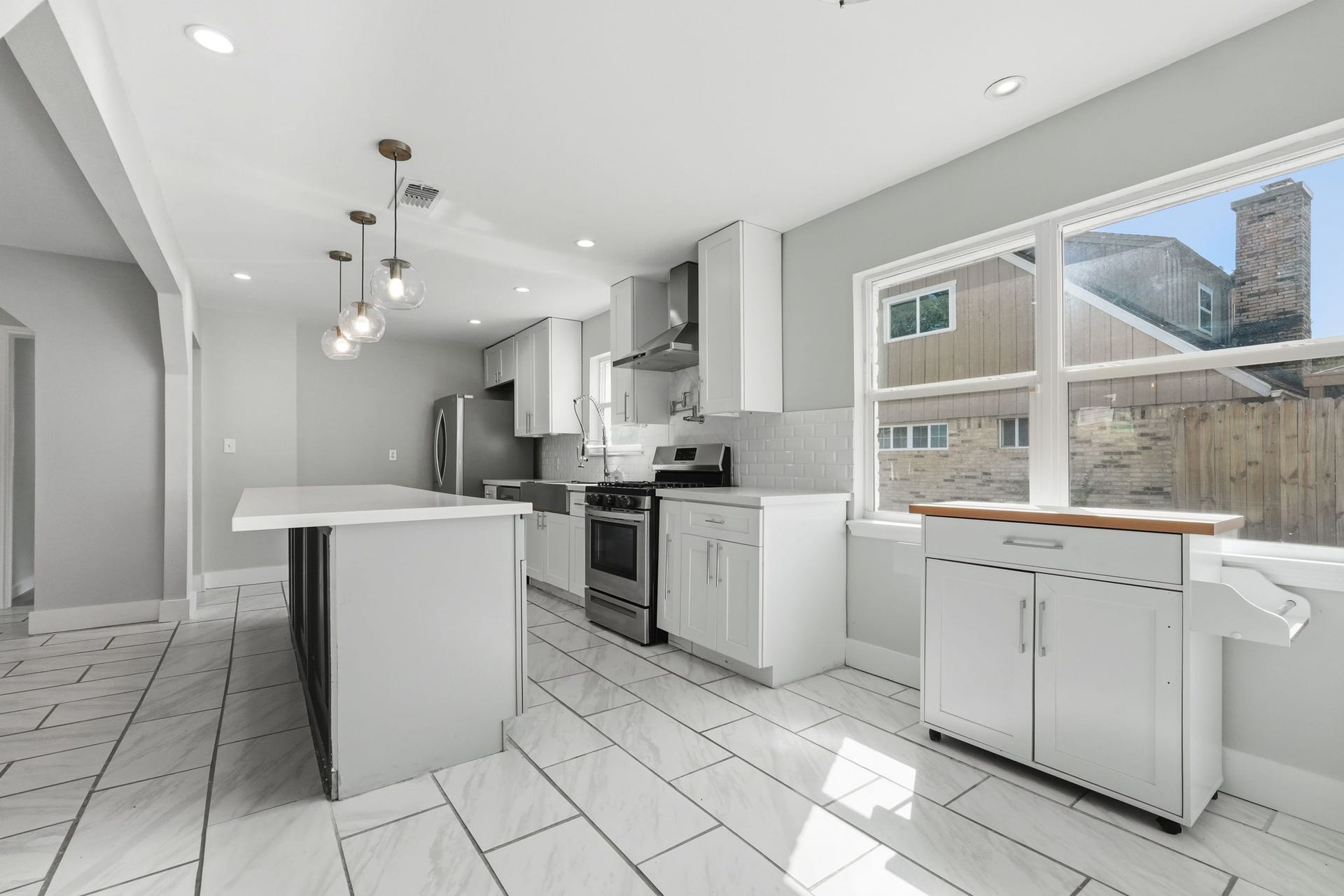 Bright and modern kitchen featuring sleek stainless steel appliances, elegant white cabinetry.