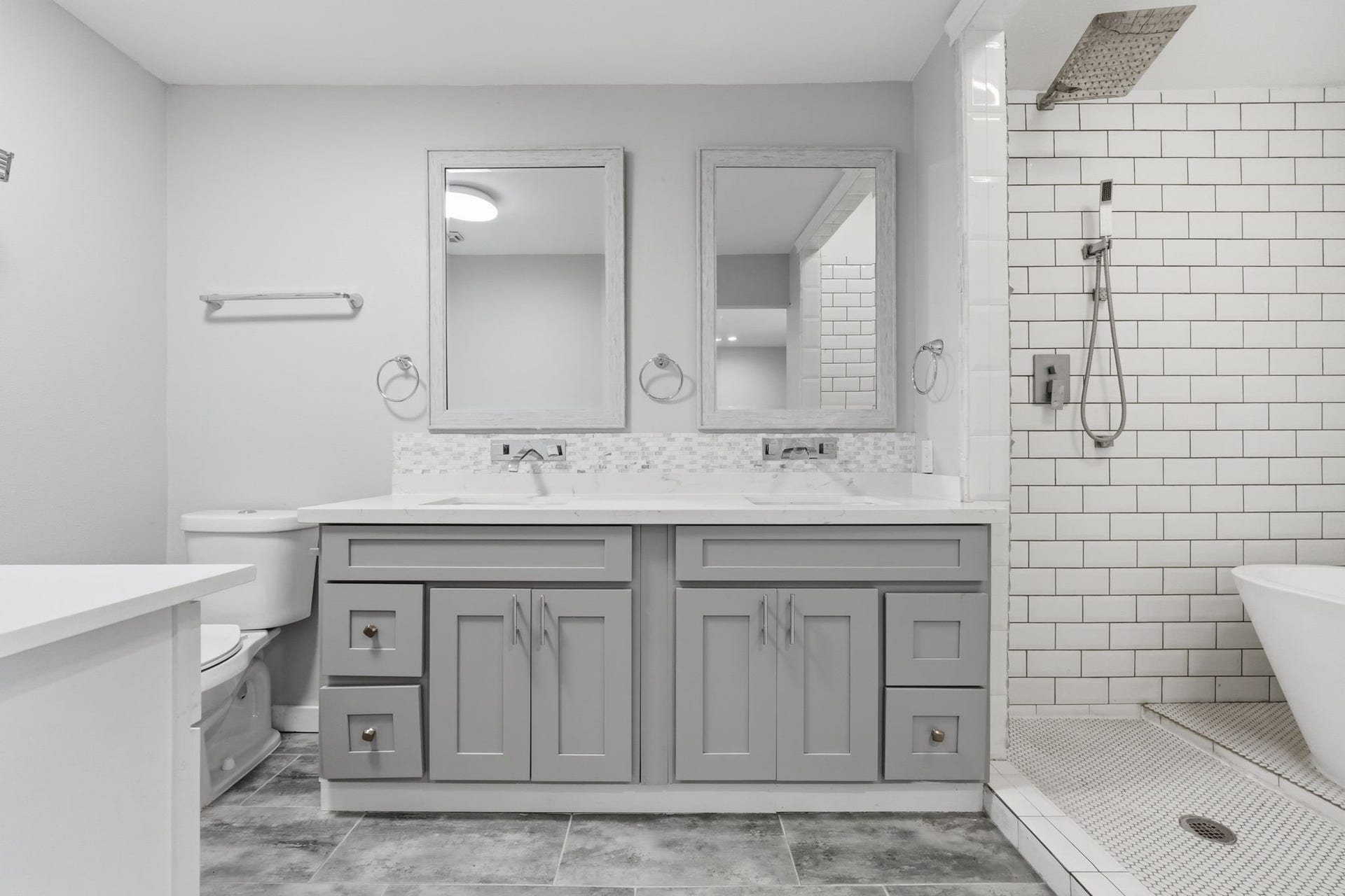 This bathroom features a dual-sink vanity with elegant gray cabinetry.