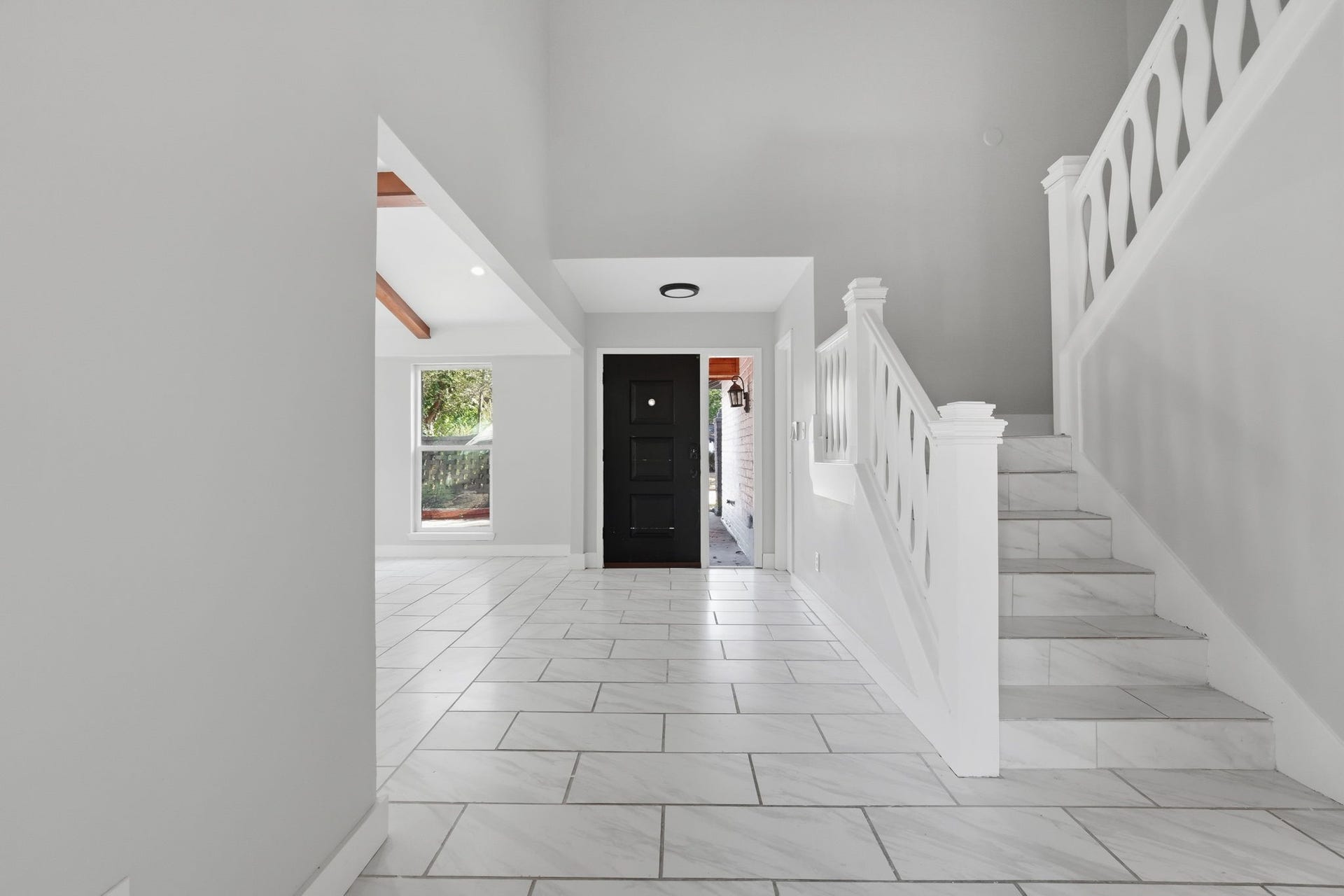 This opposite view of the grand entry way shows the connection to the living room and the stairs.