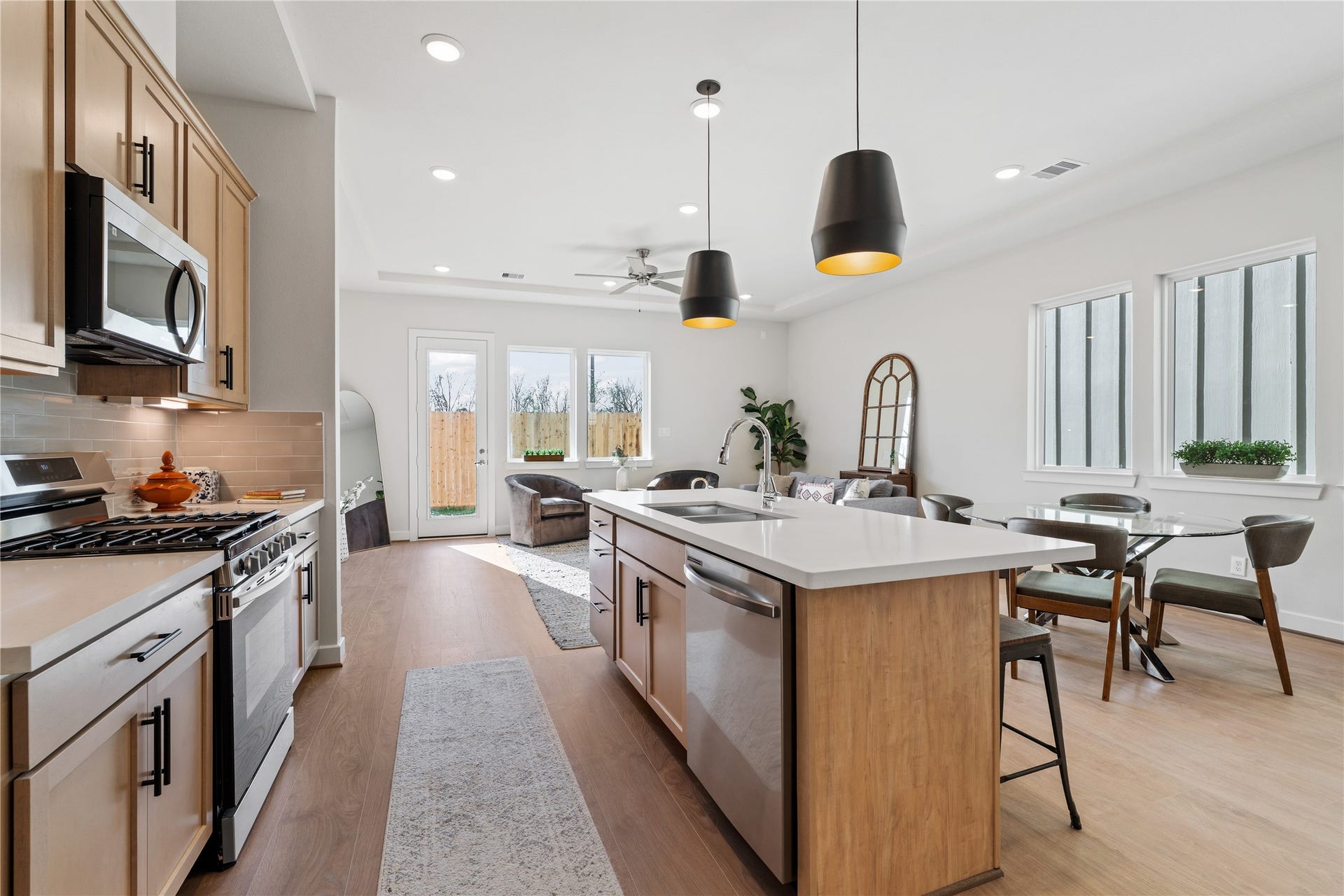 6441 Rena Street, Houston, TX 77092 Looking from the range across the island toward the dining and living areas, the whole first floor reads as one connected space.